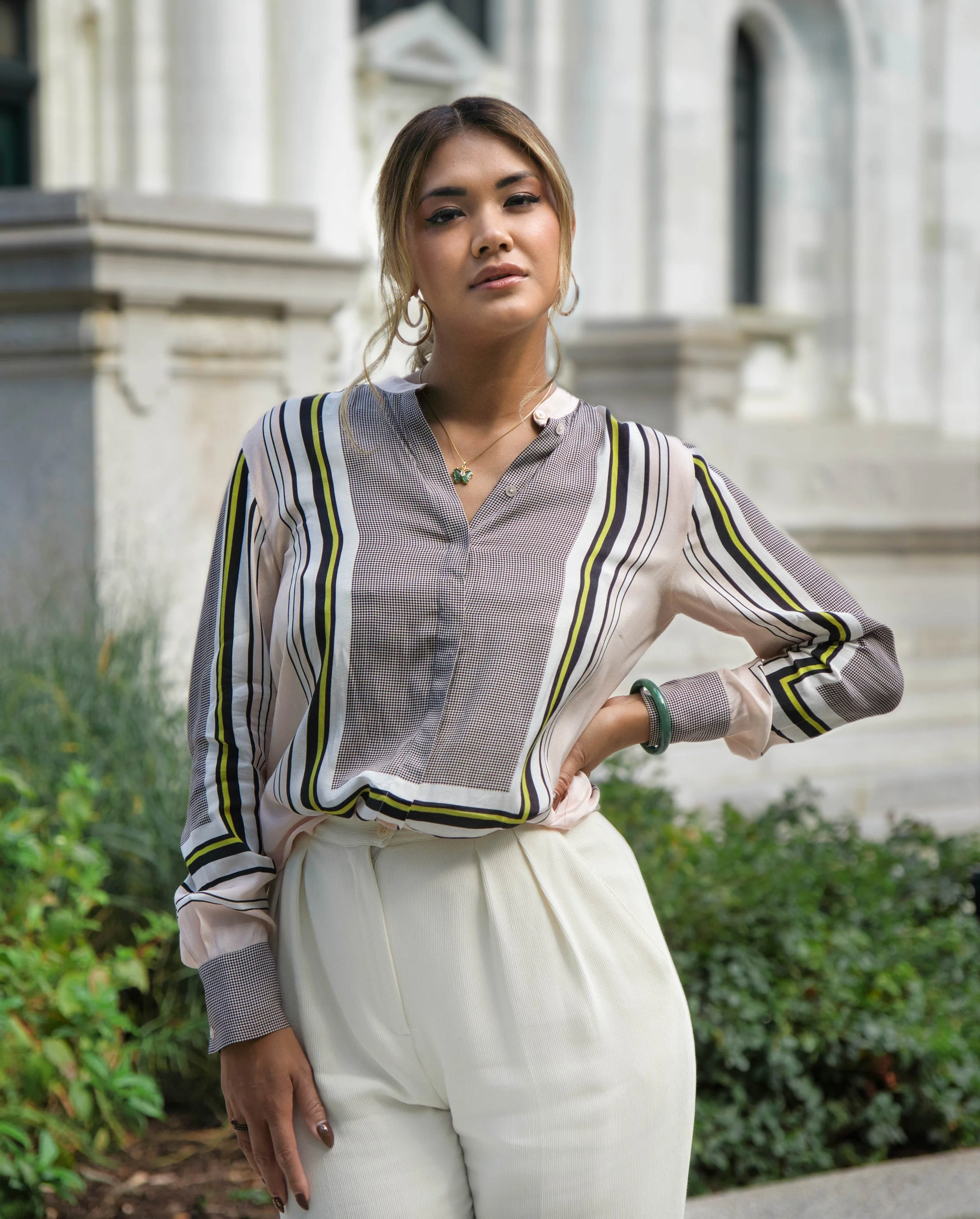 Woman posing in front of building.