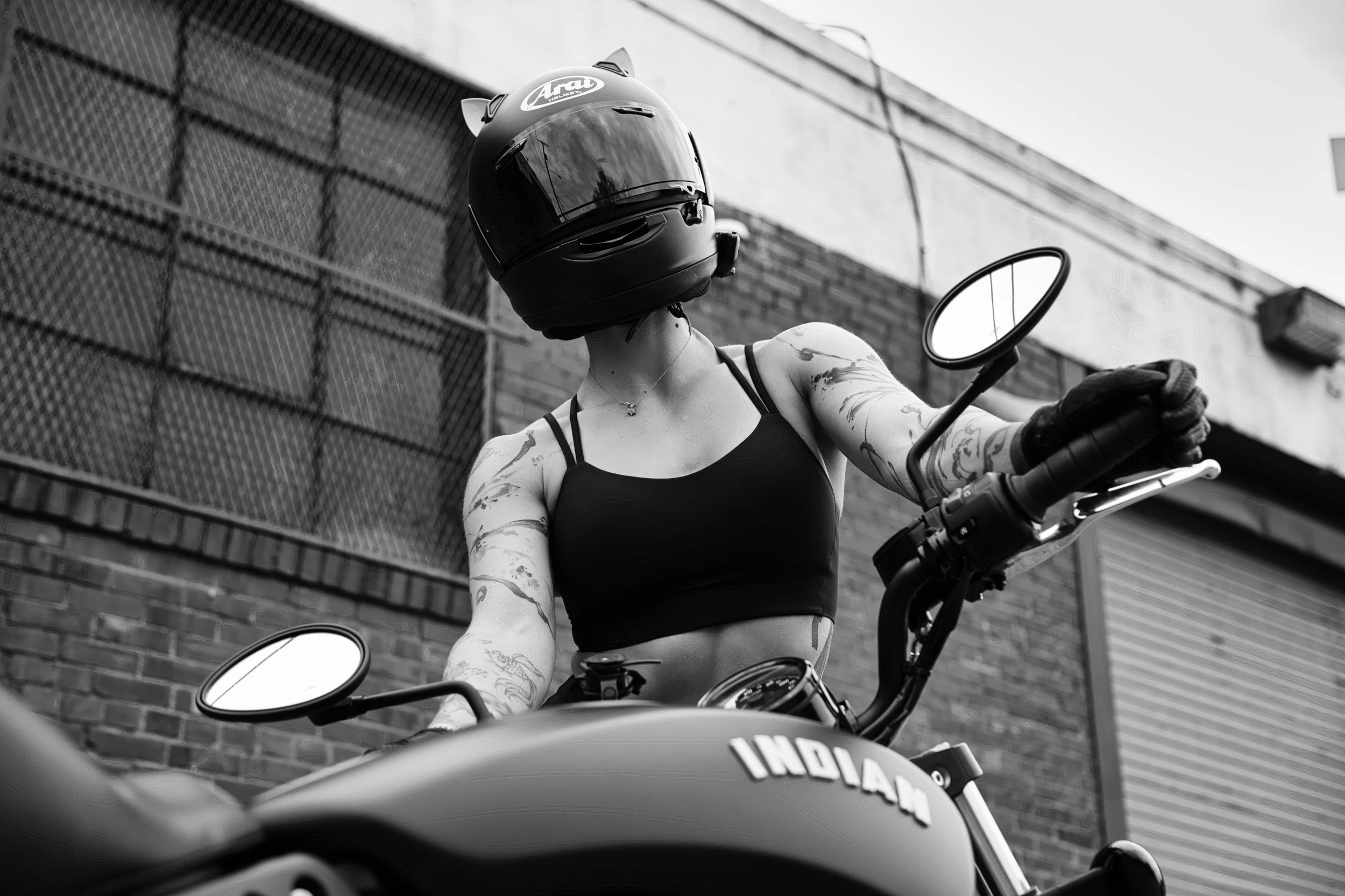 Woman standing behind motorcycle.