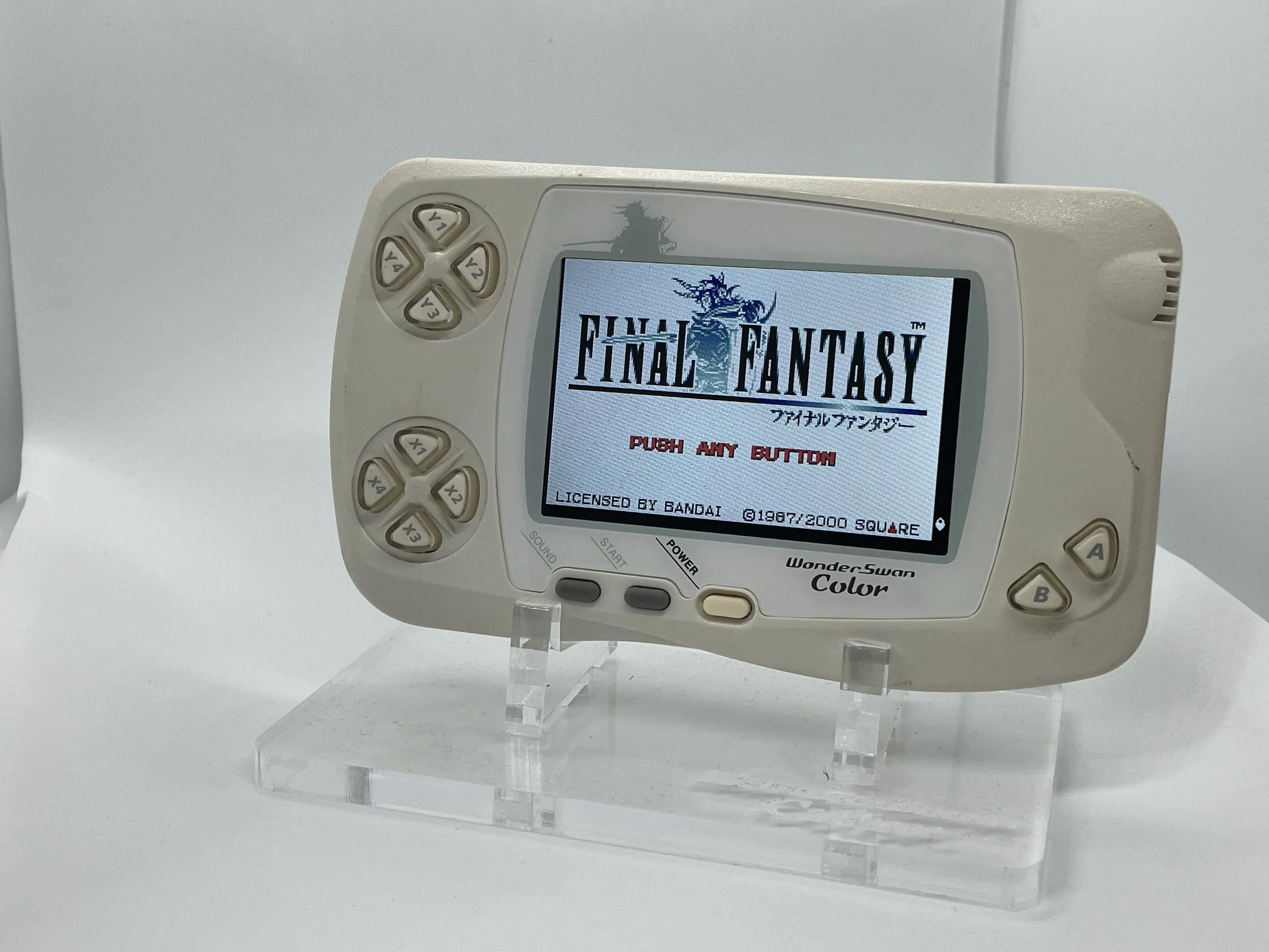 A portable hand-held gaming device displaying the title screen of the game Final Fantasy.