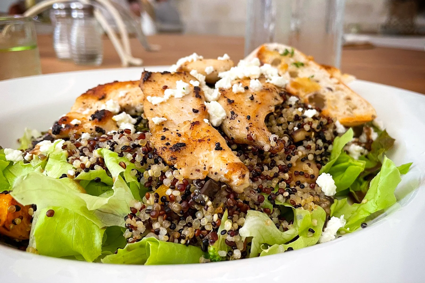 EVERYTHING QUINOA, with CHICKEN    
roasted broccoli, mushrooms, garlic, squash, feta, served on a bed of lettuce with balsamic dressing and two slices of garlic baguette