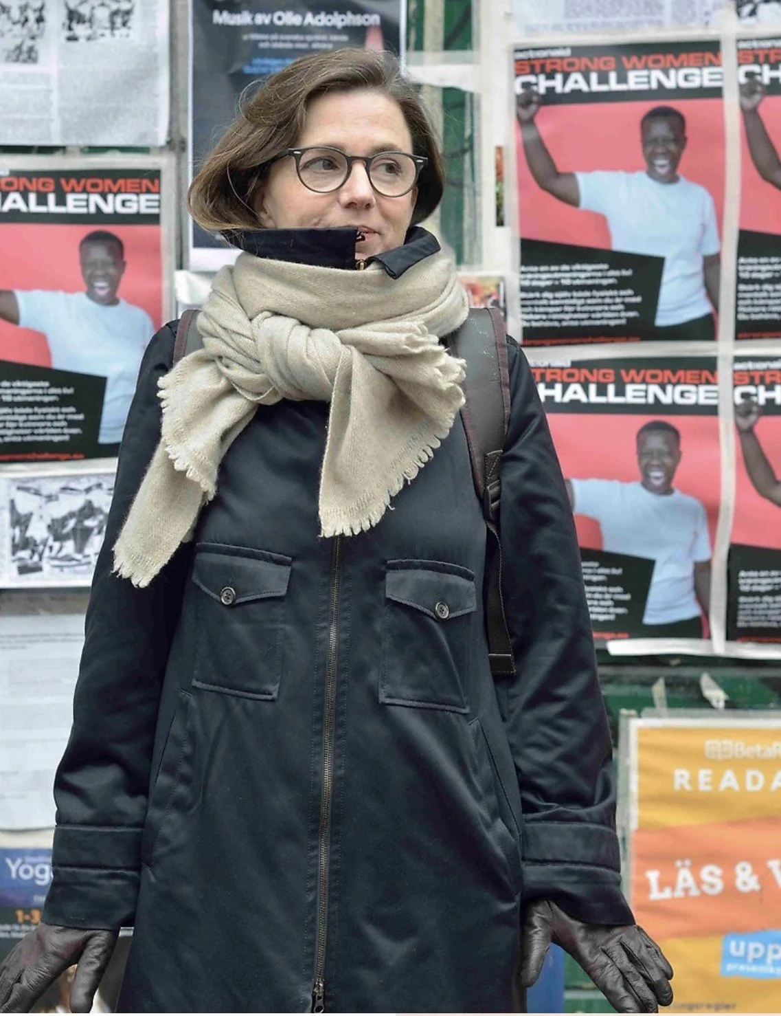 Porträtt av konstnärern Sophie Tottie. Em konstnär framför en vägg täckt av affischer.