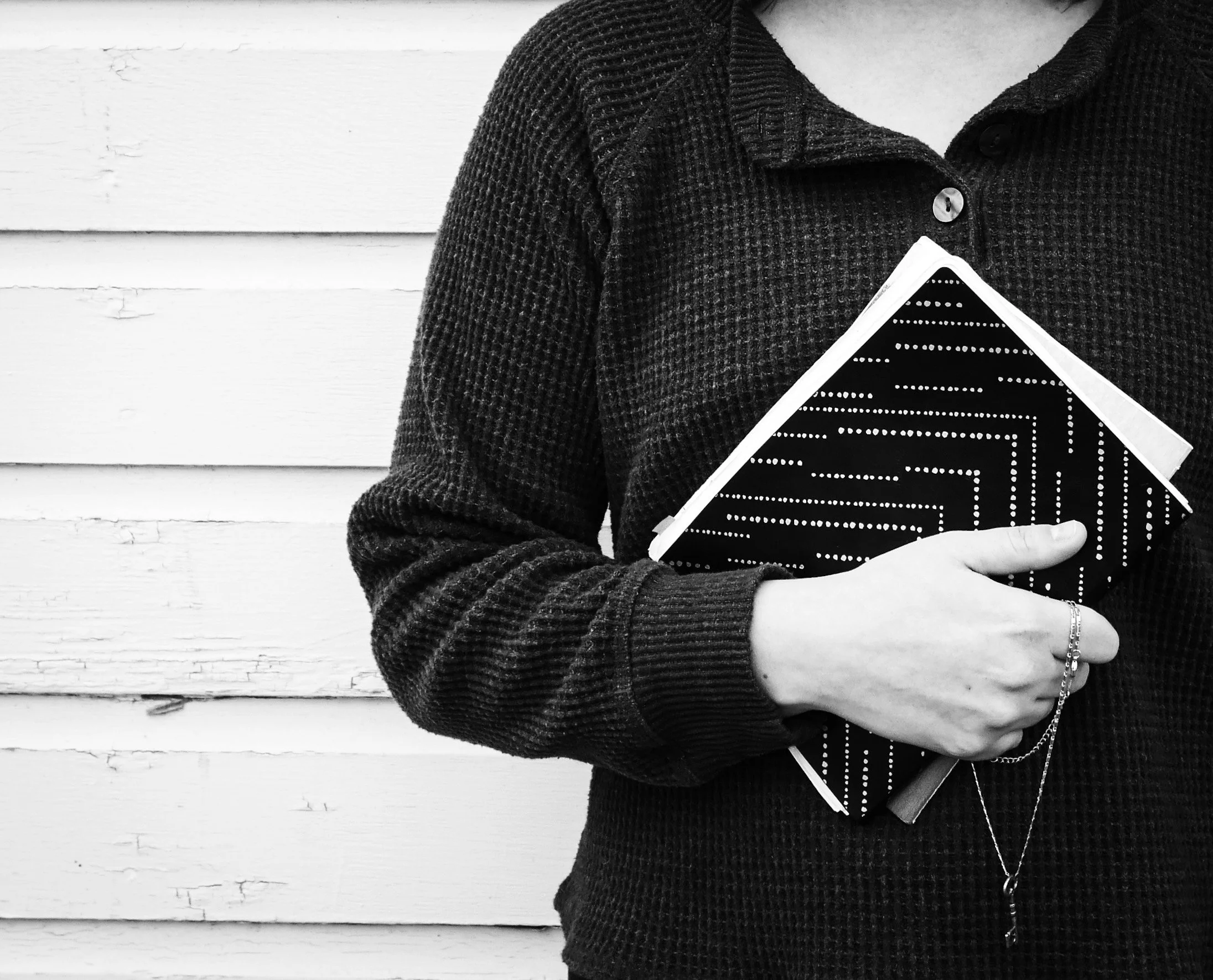 woman holding journals and a key necklace