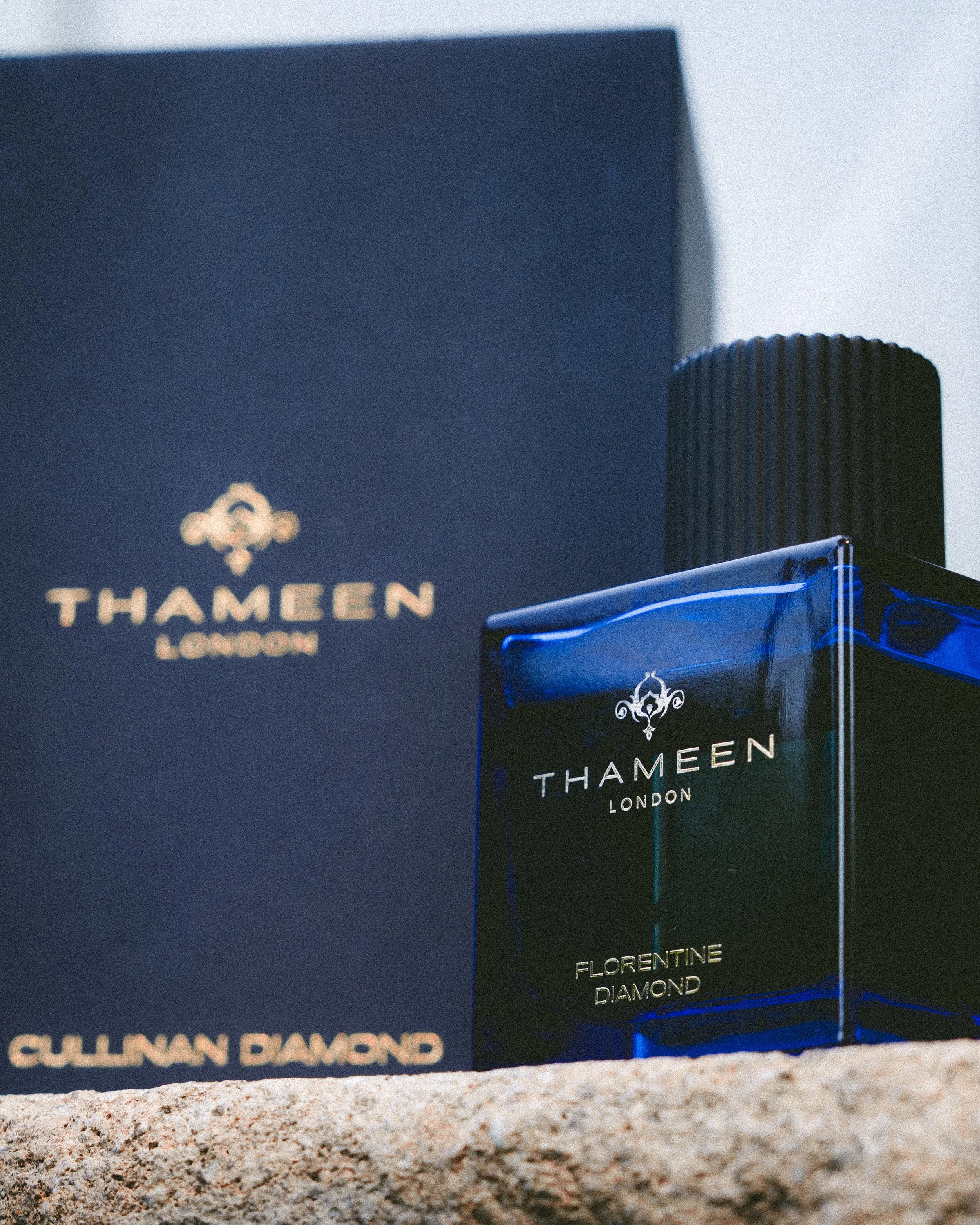 Nahaufnahme der Verpackung von Thameen London, Duft namens Florentine Diamond, auf Sandboden mit unscharfem Hintergrund.