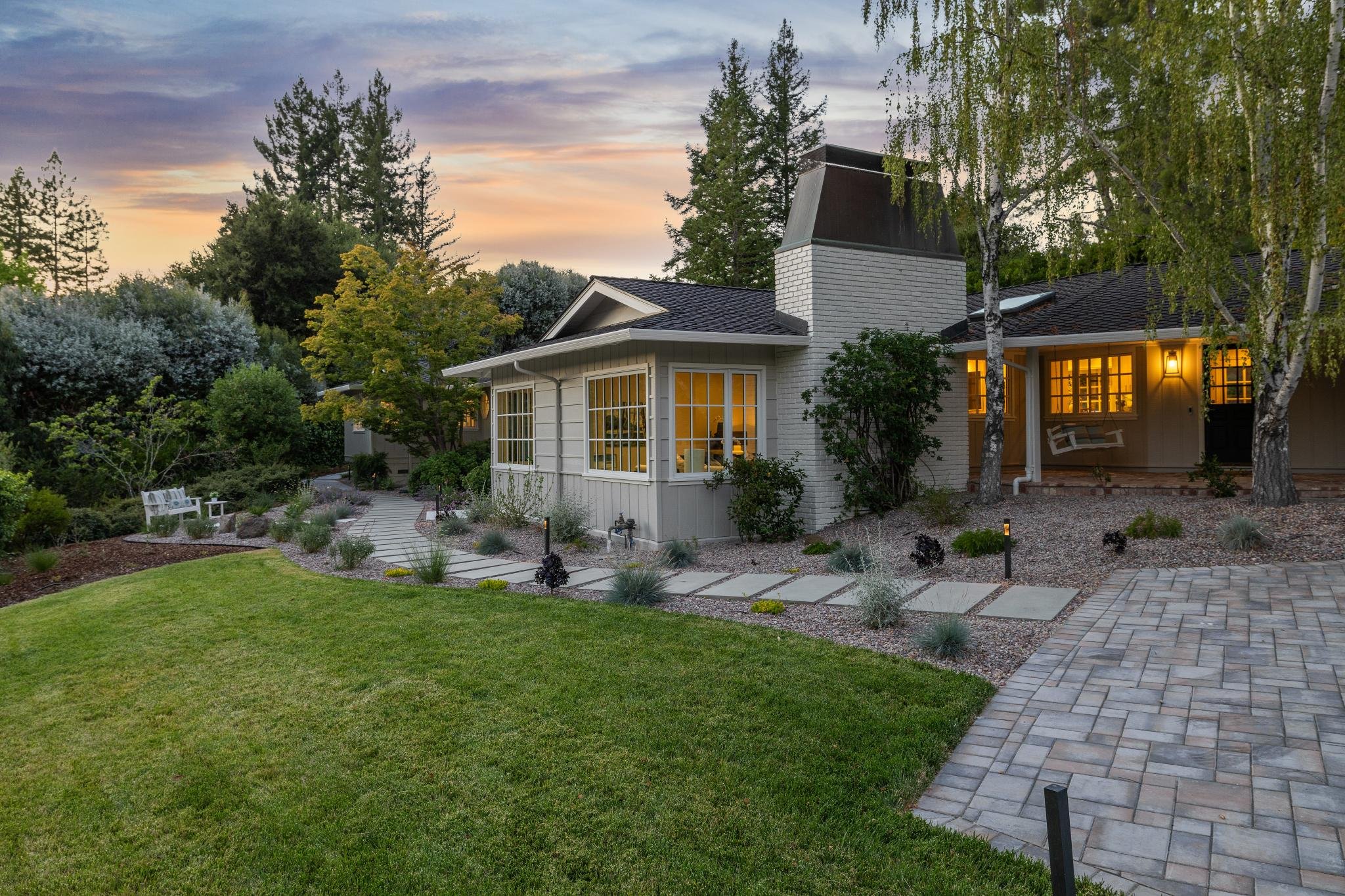 Wide, grand steppingstones lead from the parking area to the main door, creating an elegant, welcoming pathway to your serene retreat.