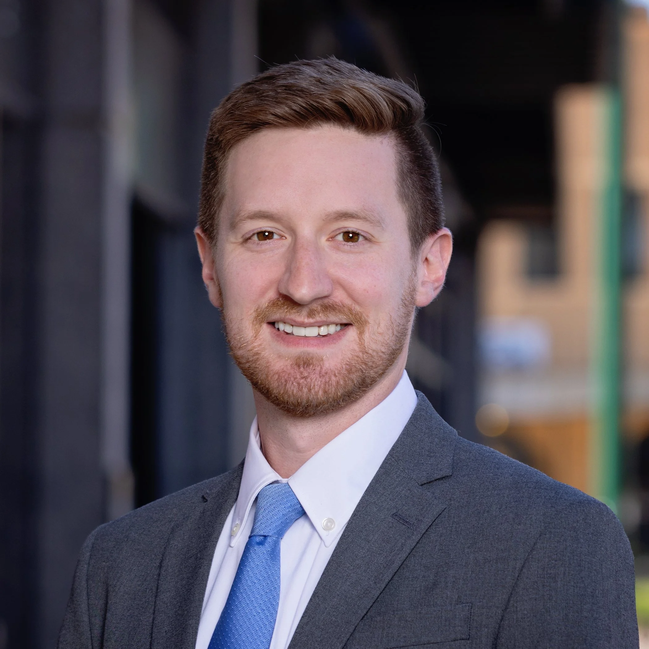 Smiling man wearing suit with a blue tie.