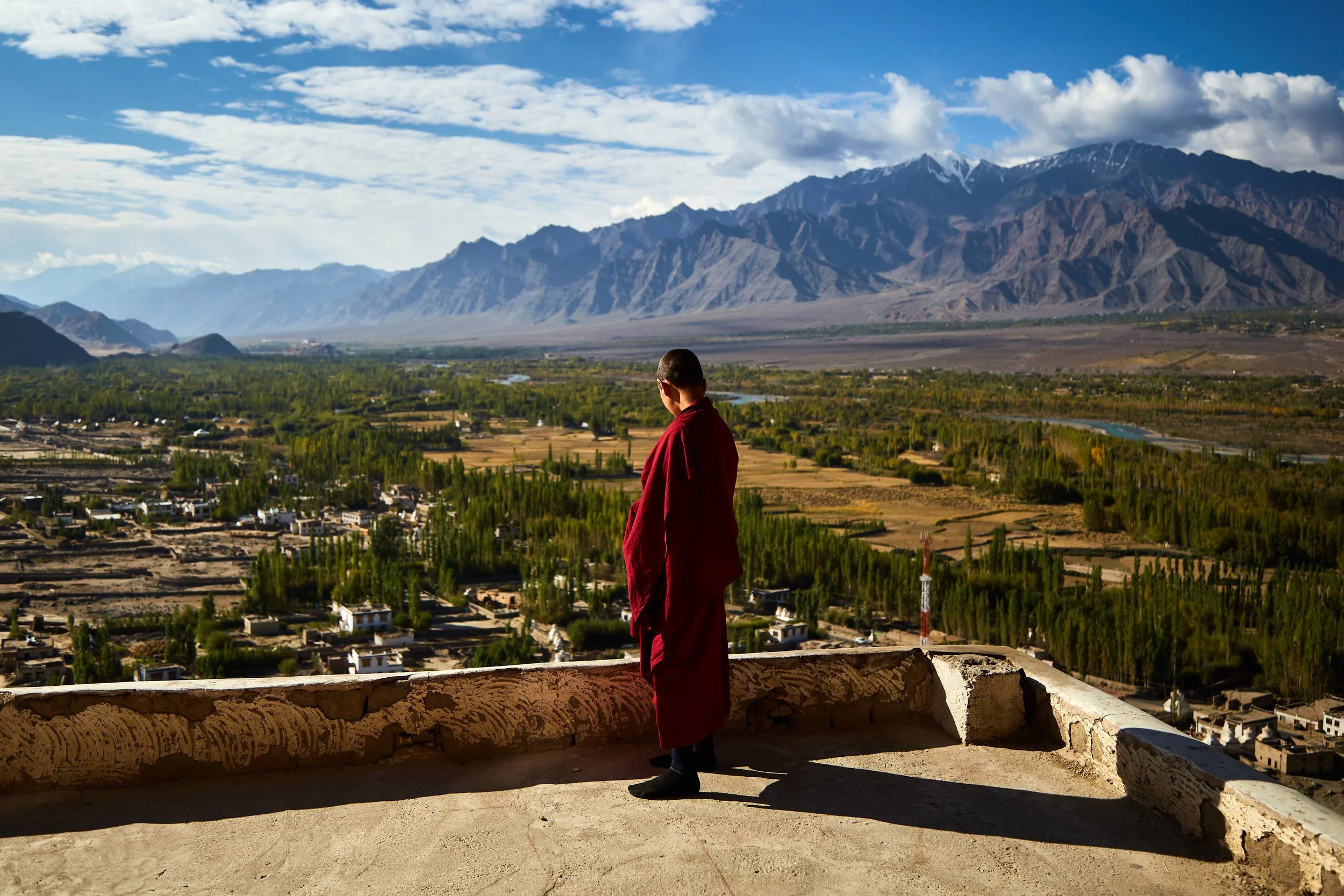 A young Buddhist monk is watching over a valley from a balcony at Thiksey monastery. Located at around 12,000 ft, it is one of the iconic and largest monasteries in Ladakh.