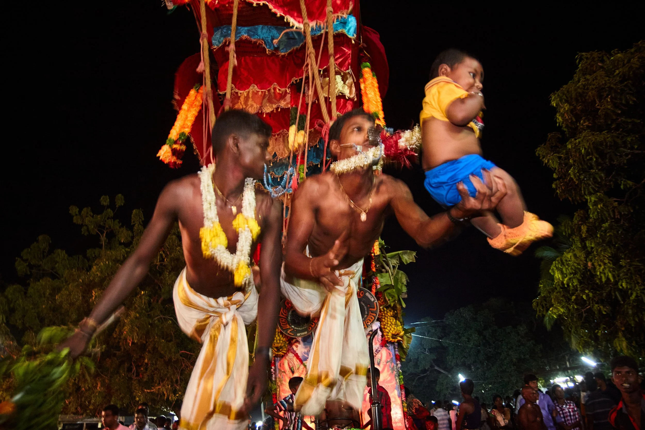A child was given to the men hanging on the hooks. Hopefully, with the trust in the energy of the tired man, the child will pendulate for several cycles, equating to him performing the ritual.