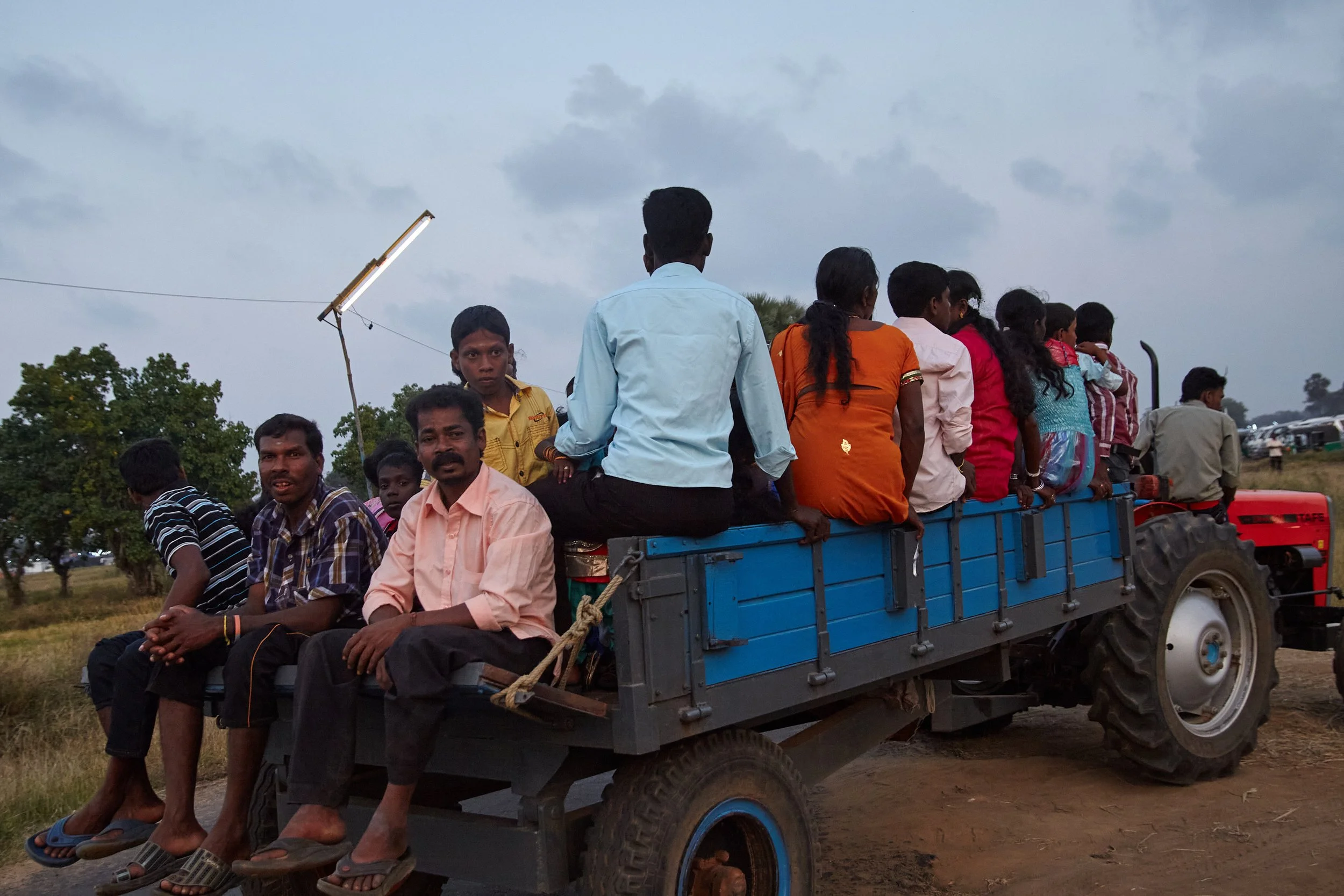 Villagers are arriving at the temple in trailers connected to the tractors. This is a well-established and cost-effective method to transport many people in the region even during the peaks of the war.