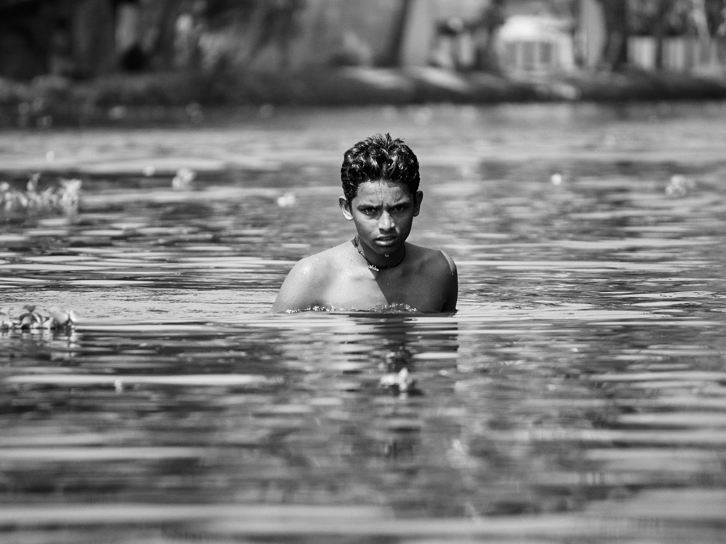 A boy enjoying a bath in the canal. Families depend on the backwater for the many of their household needs including cooking, bathing, laundry, transport, fishing etc.
