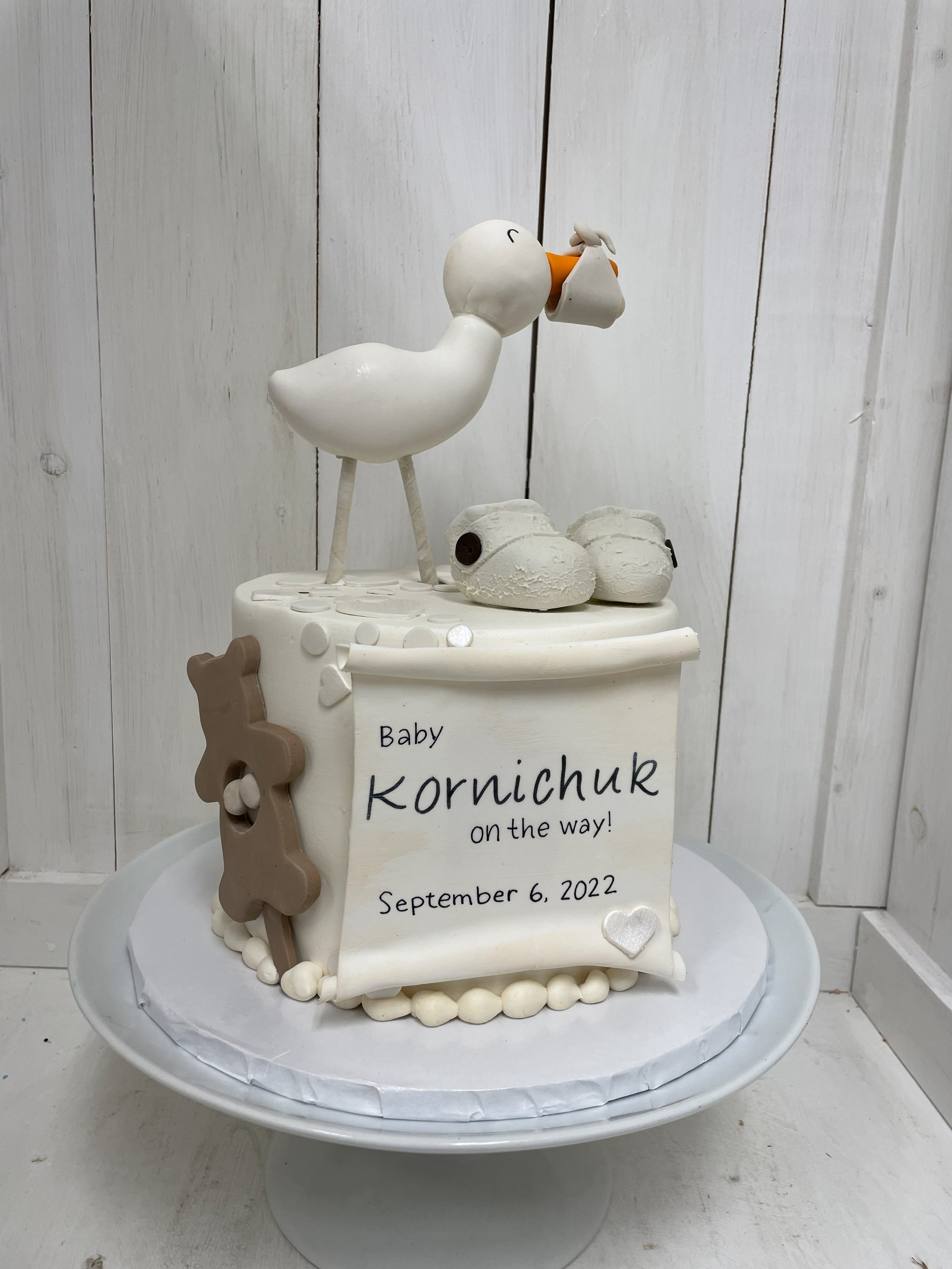 stork baby shower cake with baby shoes and rattle.jpeg