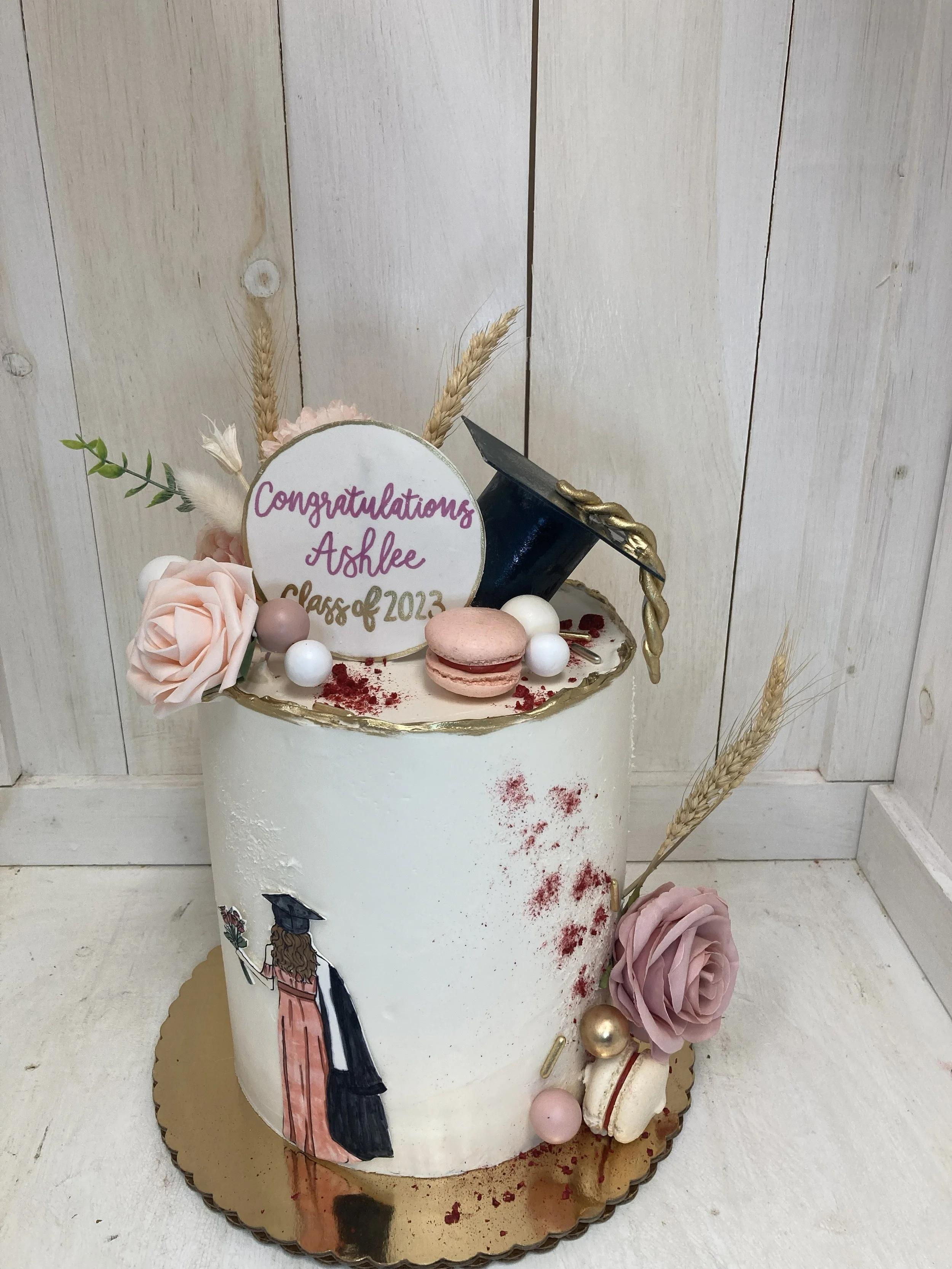 girl in a dress graduation cake elegant with pink and french macarons flowers.jpg