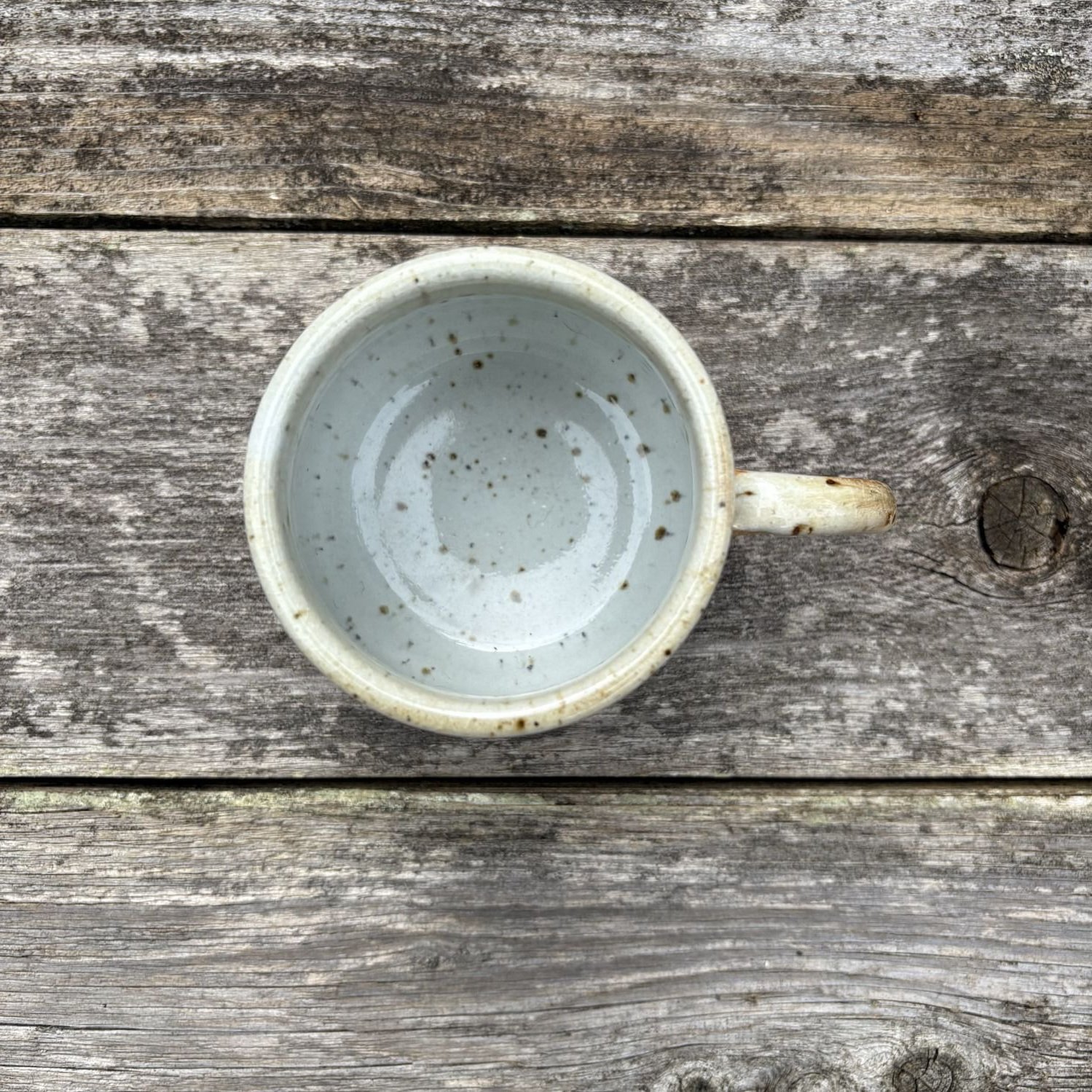 Overhead view of mug showing white rim and interior speckled with iron from the clay.