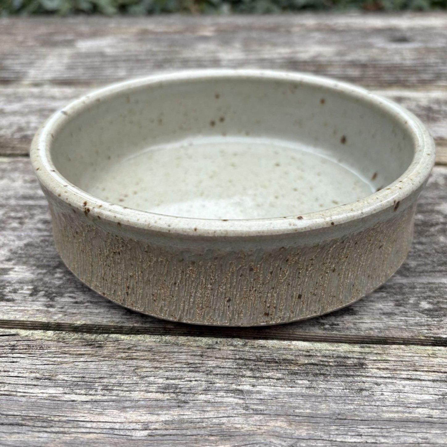 Slightly overhead view of celadon green bowl with chattered exterior.