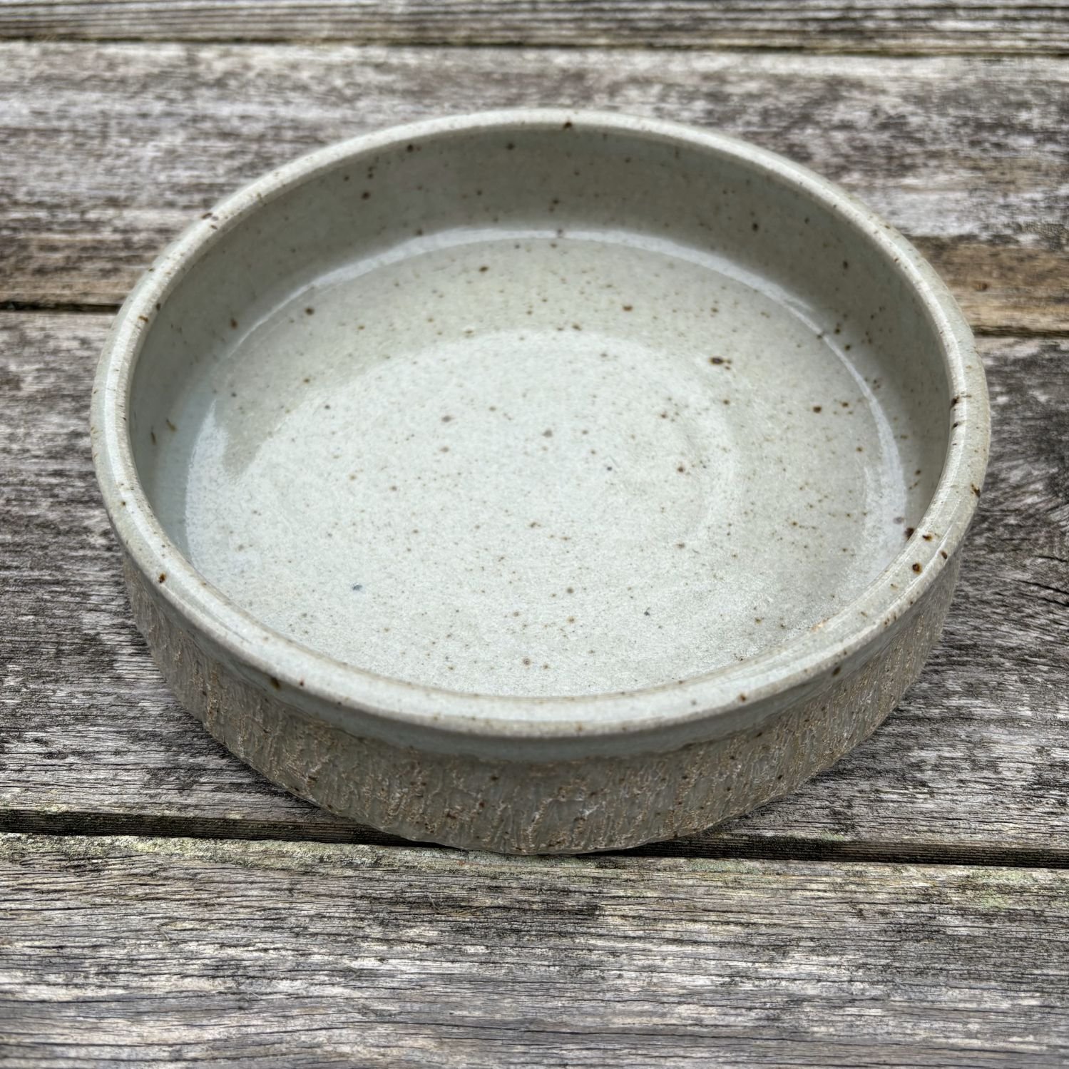 Slightly overhead view of celadon green bowl with chattered exterior.