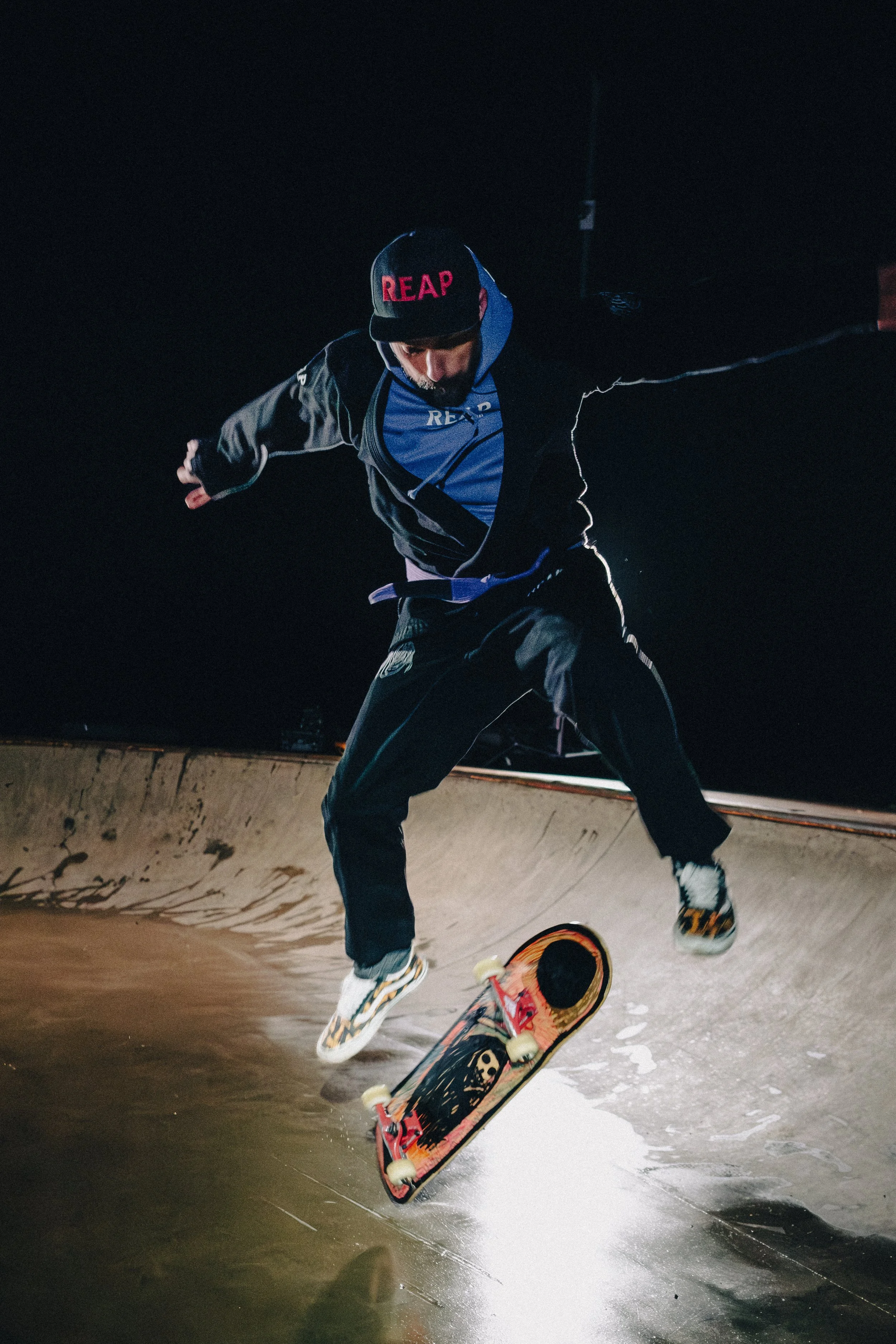 Skateboarder performing a trick on a ramp at night