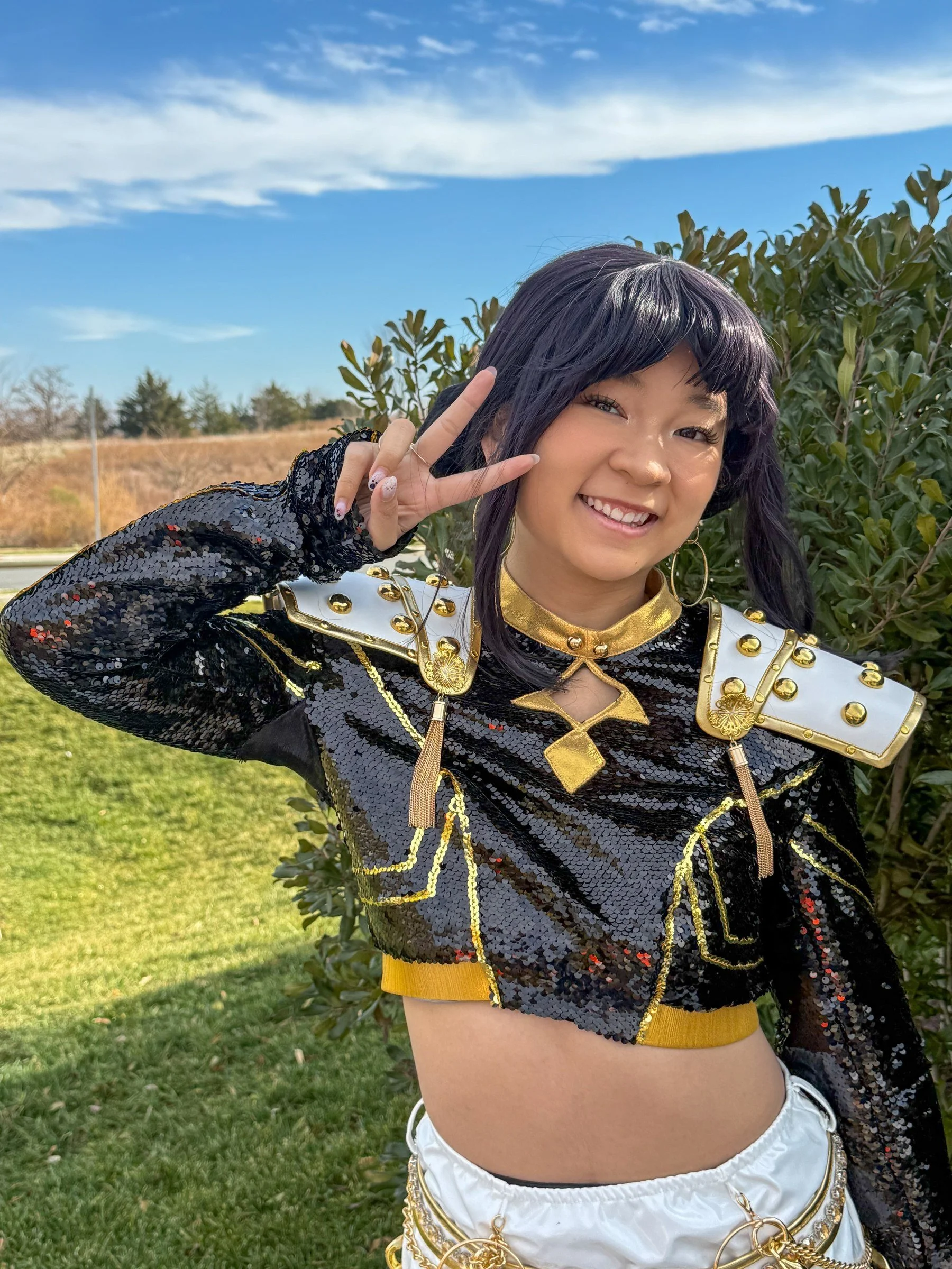 K-Pop lyricist character in a sequined jacket giving a peace sign outdoors