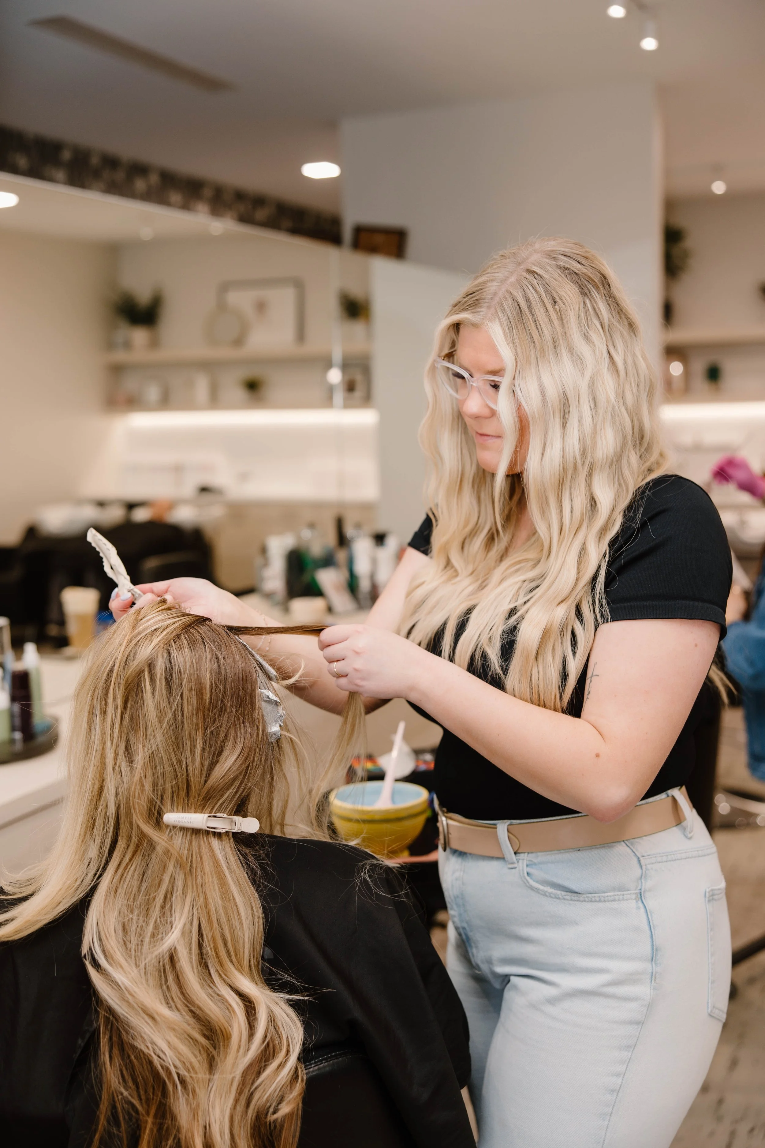 Stylist applying foil highlights to client's hair at Cedar Rose Salon & Suites in Byron Center, Michigan