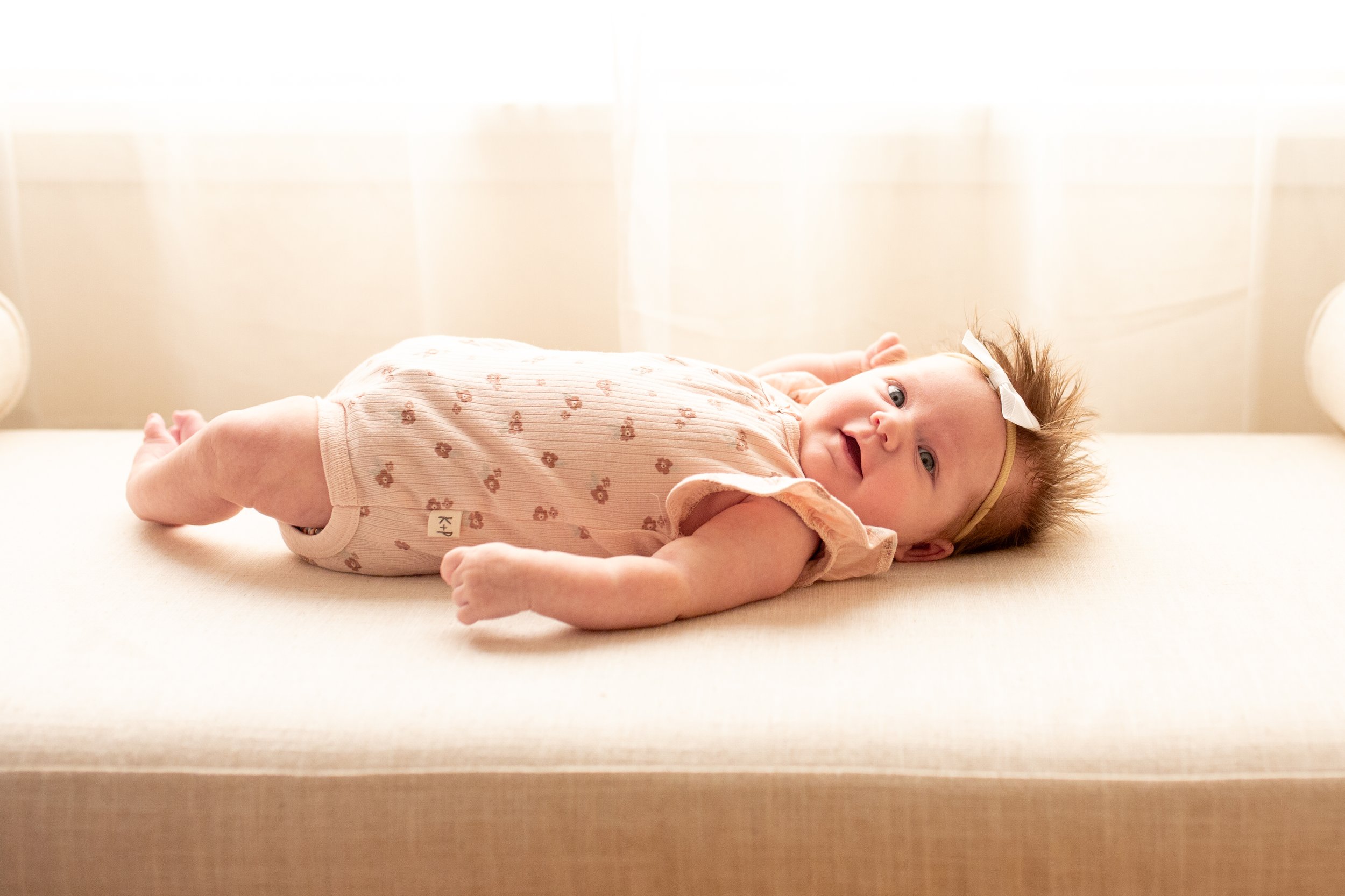 2 Month old baby smiles for the camera in natural light studio in downtown Bozeman, MT. Wanderbirth Photo, Mikaela DiBerardinis