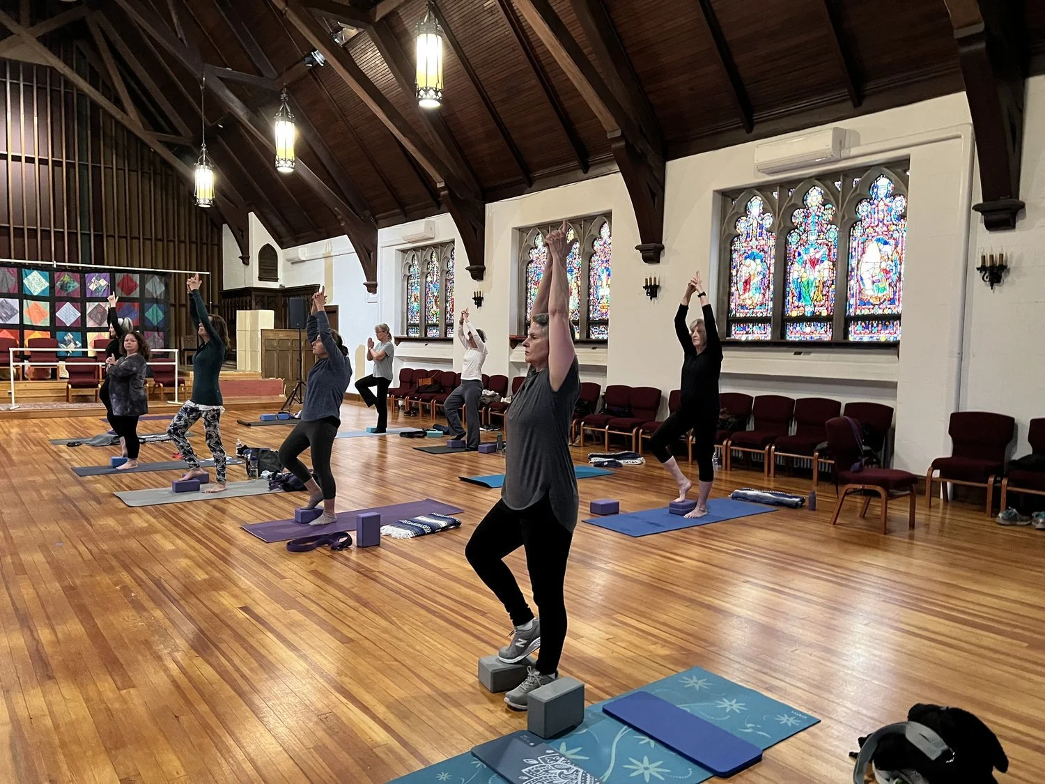 People doing yoga in the Great Hall of the Park Avenue Community Center