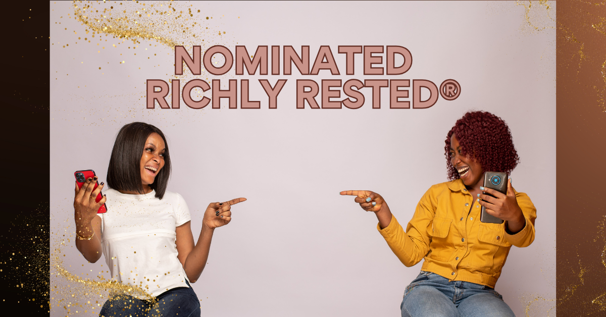 Two Black women sitting across from each other, holding cellphones, and pointing at each other while smiling. One wearing a white shirt and jeans, and the other wearing a yellow top with jeans. The words 'Nominated Richly Rested' behind them.