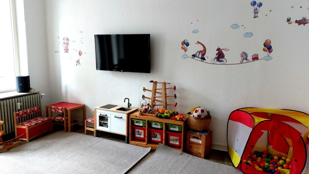 Spielzimmer mit Spielzeug, Fernseher und Wanddeko, Kinderzimmer