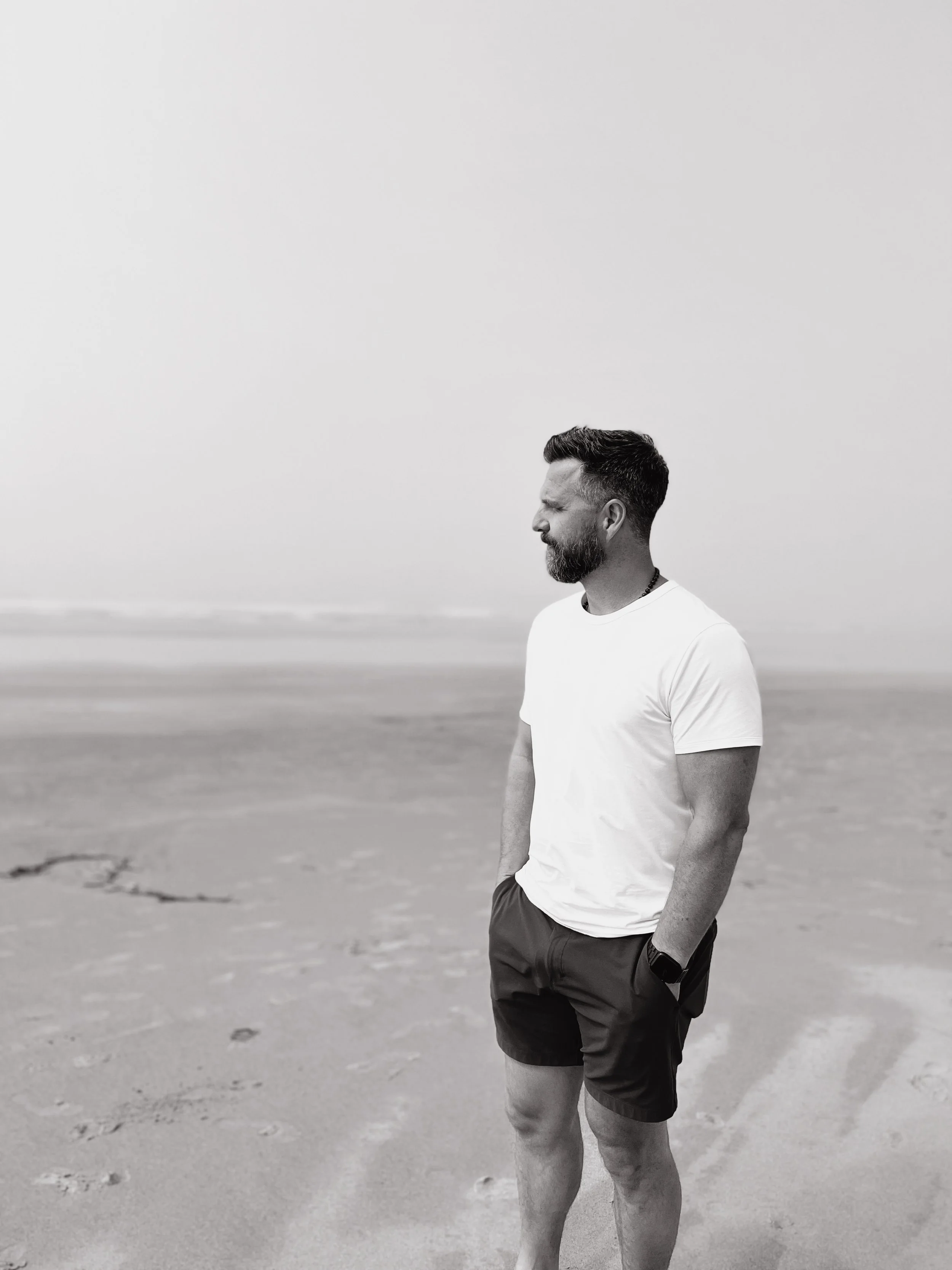 Craig Wanless, Counselling Therapist, standing on a beach looking toward the horizon.