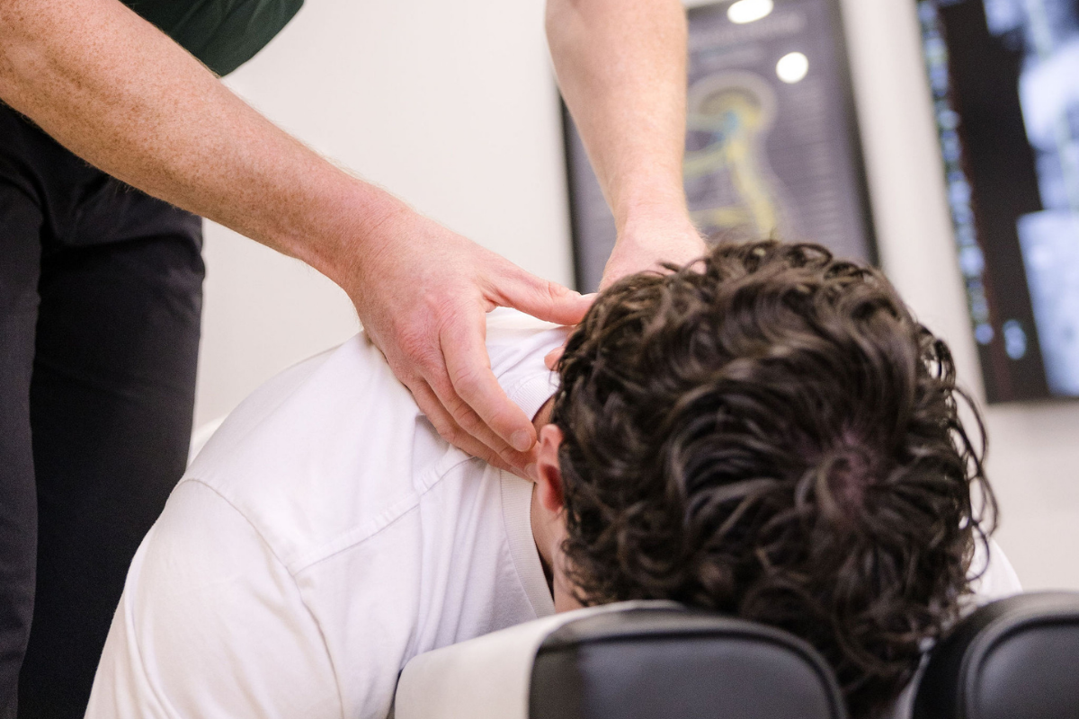 Chiropractor checking neck.
