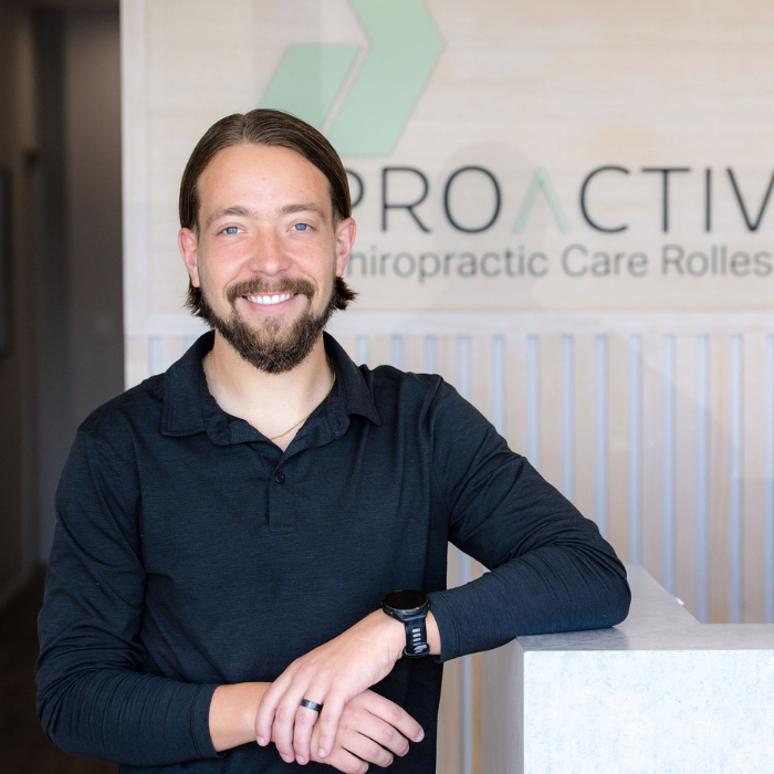Carson leaning on desk profile photo.