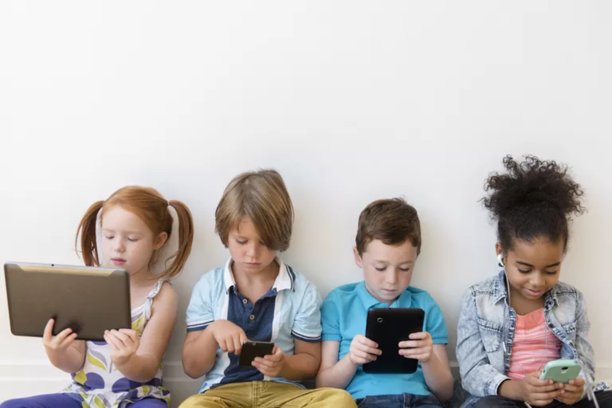 Group of children looking at devices.