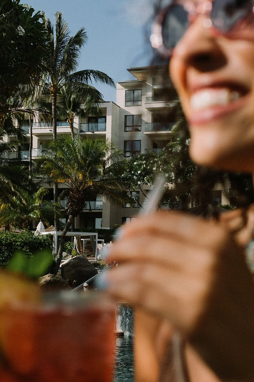 woman smiling with cocktail by the pool at Kapalua Resort for Travel and Leisure by Daeja Fallas