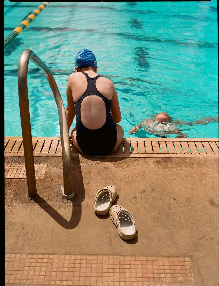 Young athletic swimmer sitting by the pool.  photographed by daeja fallas, Los angeles and Hawaii based photographer specializing in athletics, lifestyle, beauty and portraiture. athletic photography, lifestyle photographer in Los Angeles