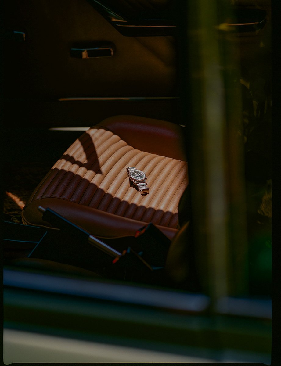 Seiko x Rowing Blazers racing watch on seat ov a vintage Aston Martin, photography by Daeja Fallas for Esquire UK.