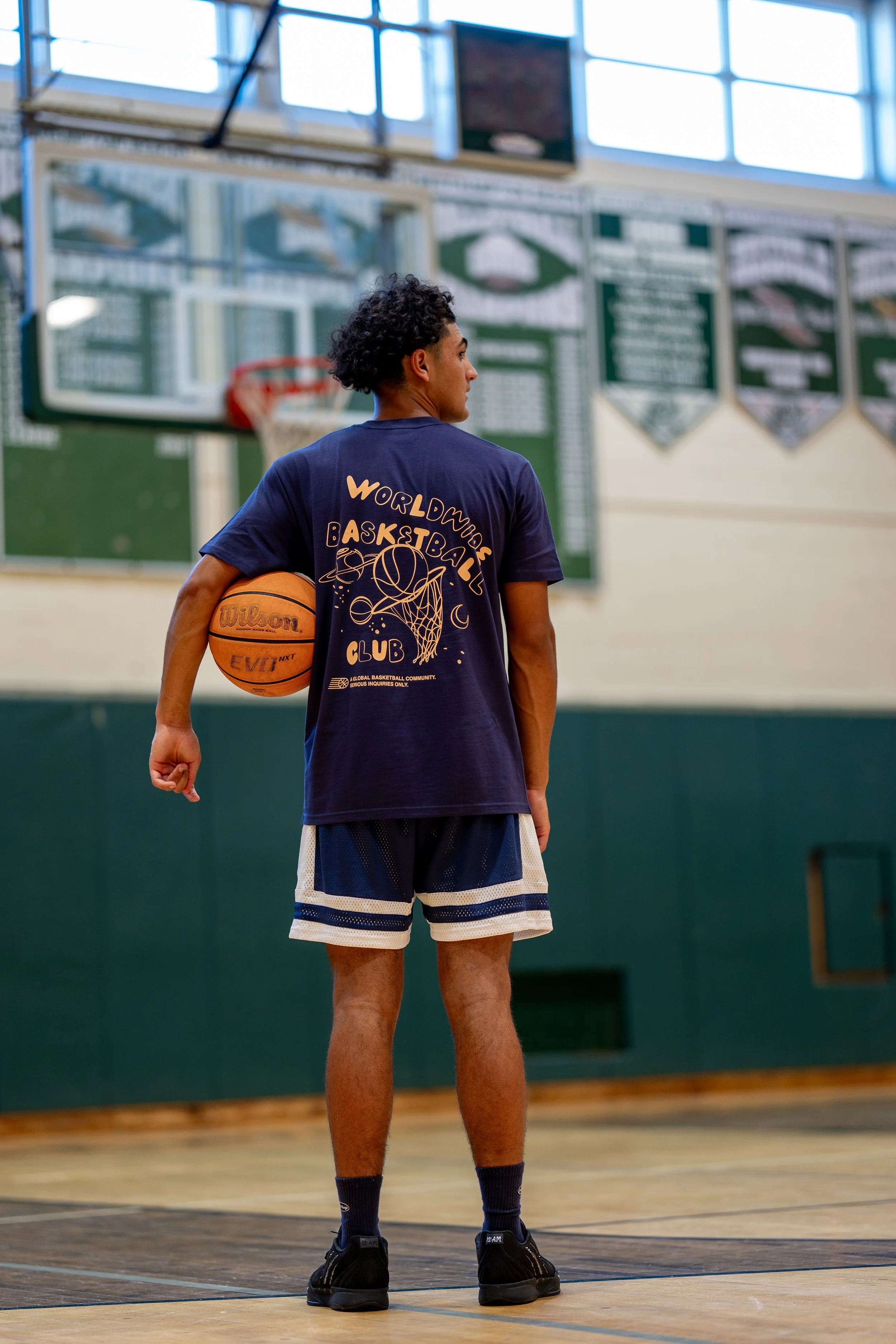 Man holding basketball branded shirt