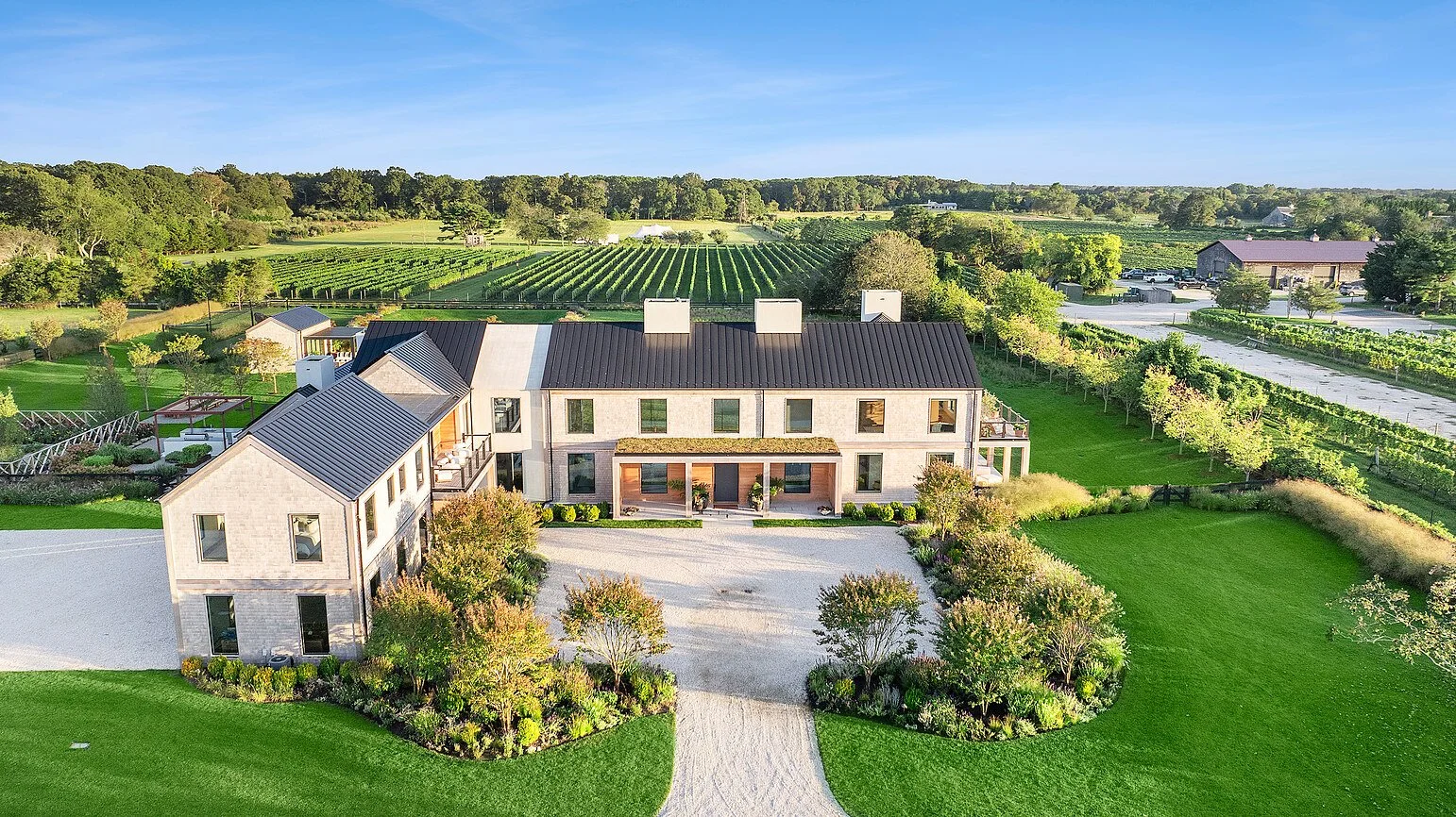 Aerial view of a Hamptons estate with gravel courtyard beside vineyard rows