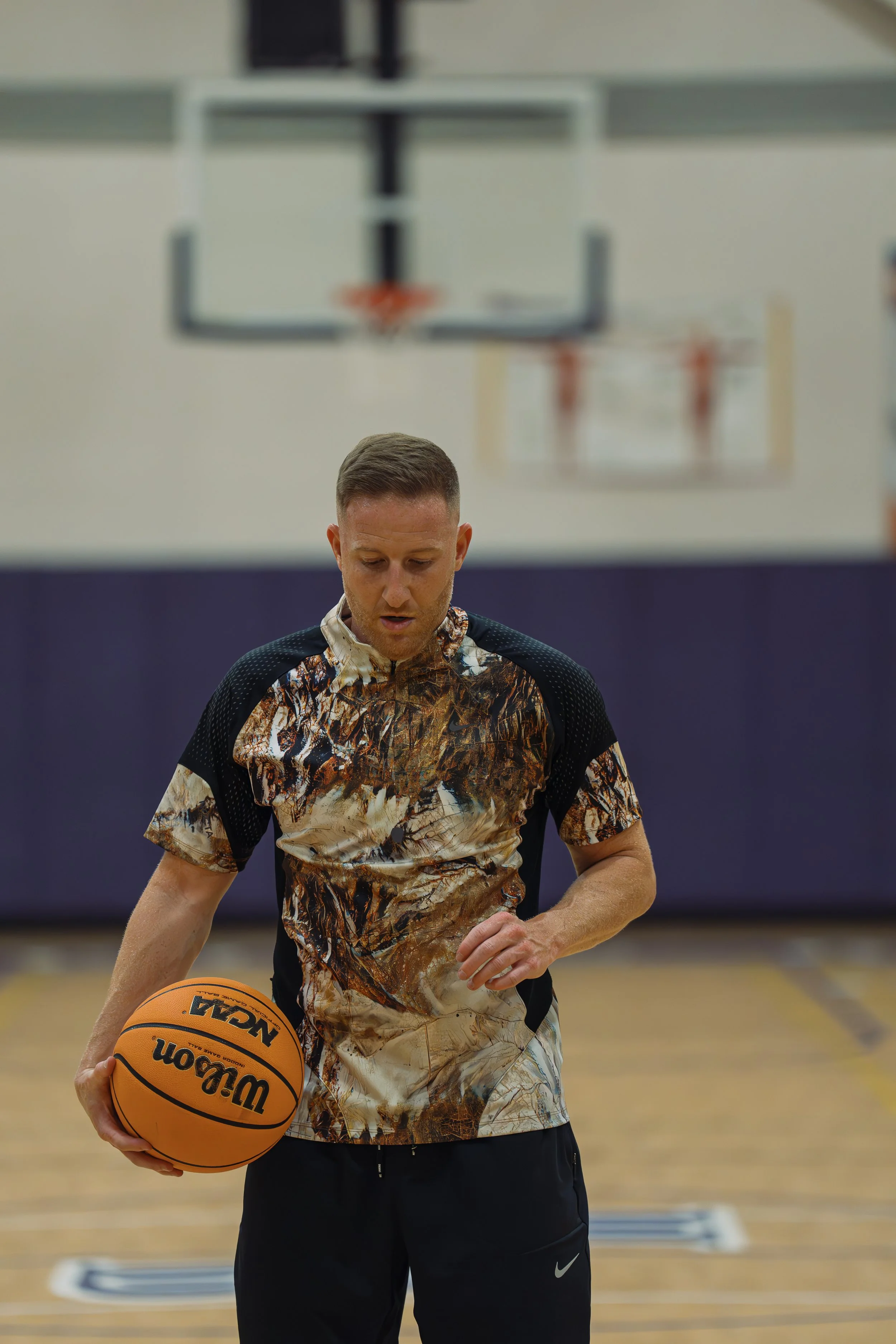 man holding basketball looking down