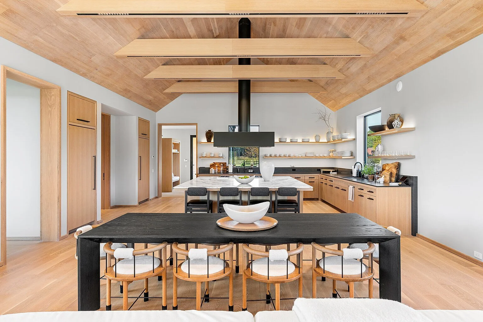 Modern kitchen and dining area with a vaulted oak ceiling in a Hamptons home