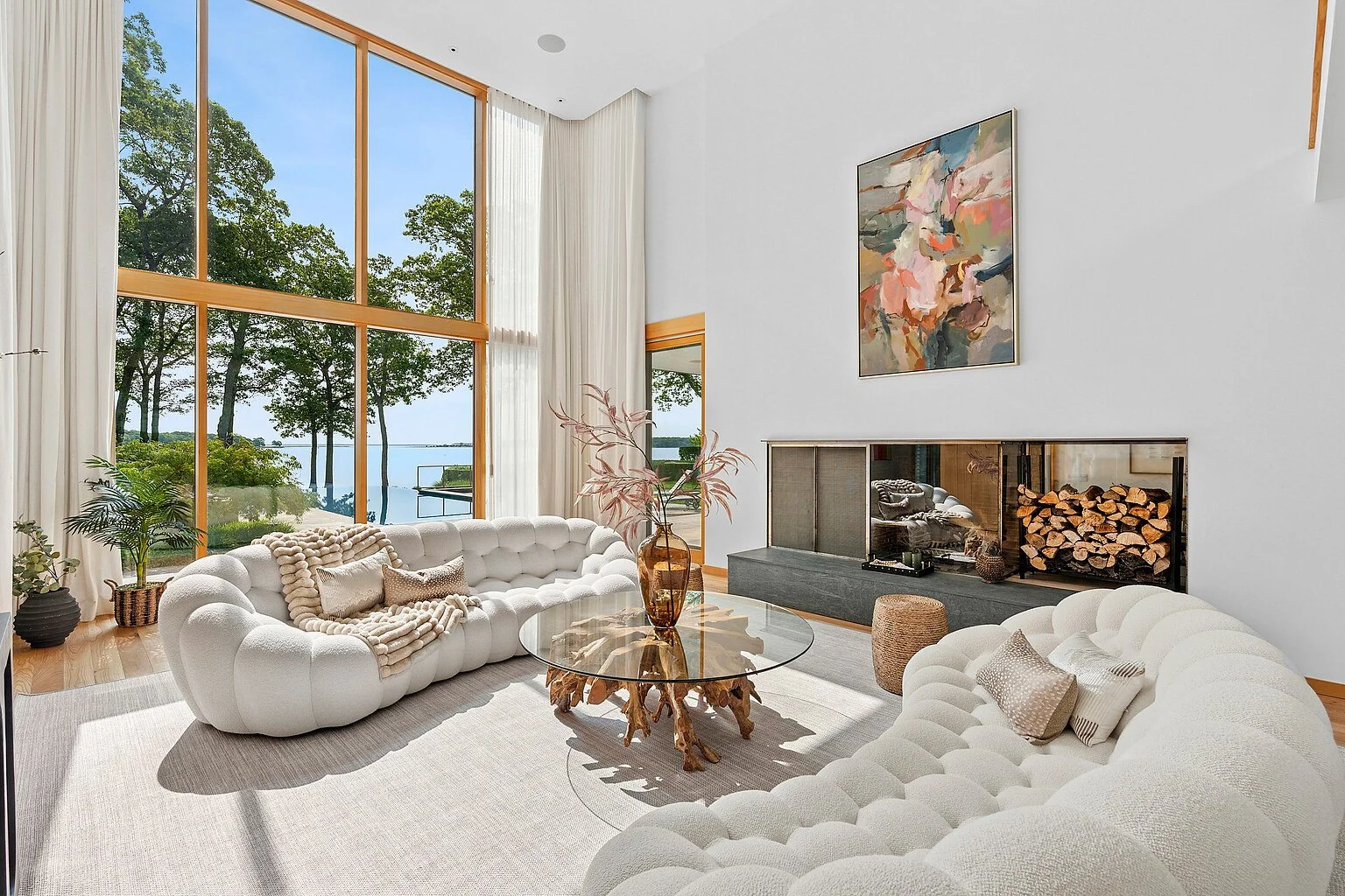 Double-height living room with floor-to-ceiling windows overlooking the water