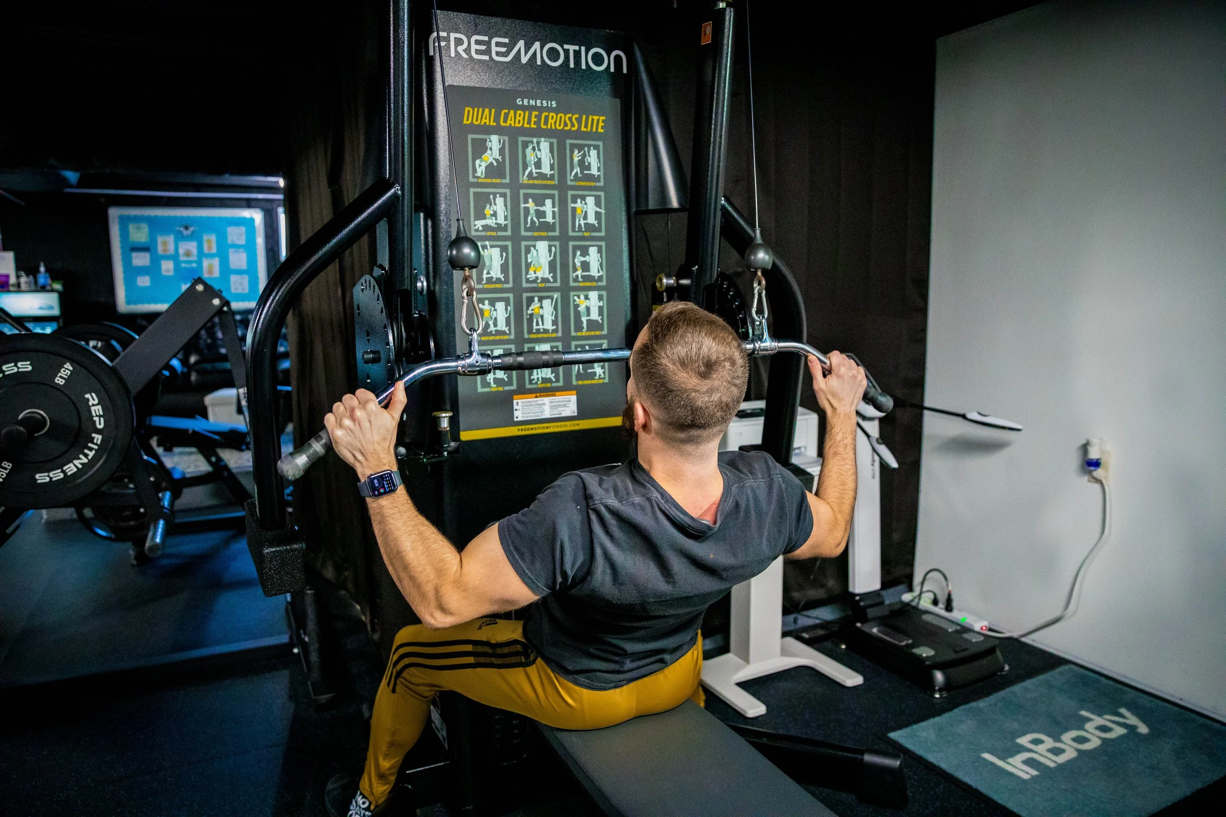 Man using a weight machine in a gym, focusing on upper body workout.