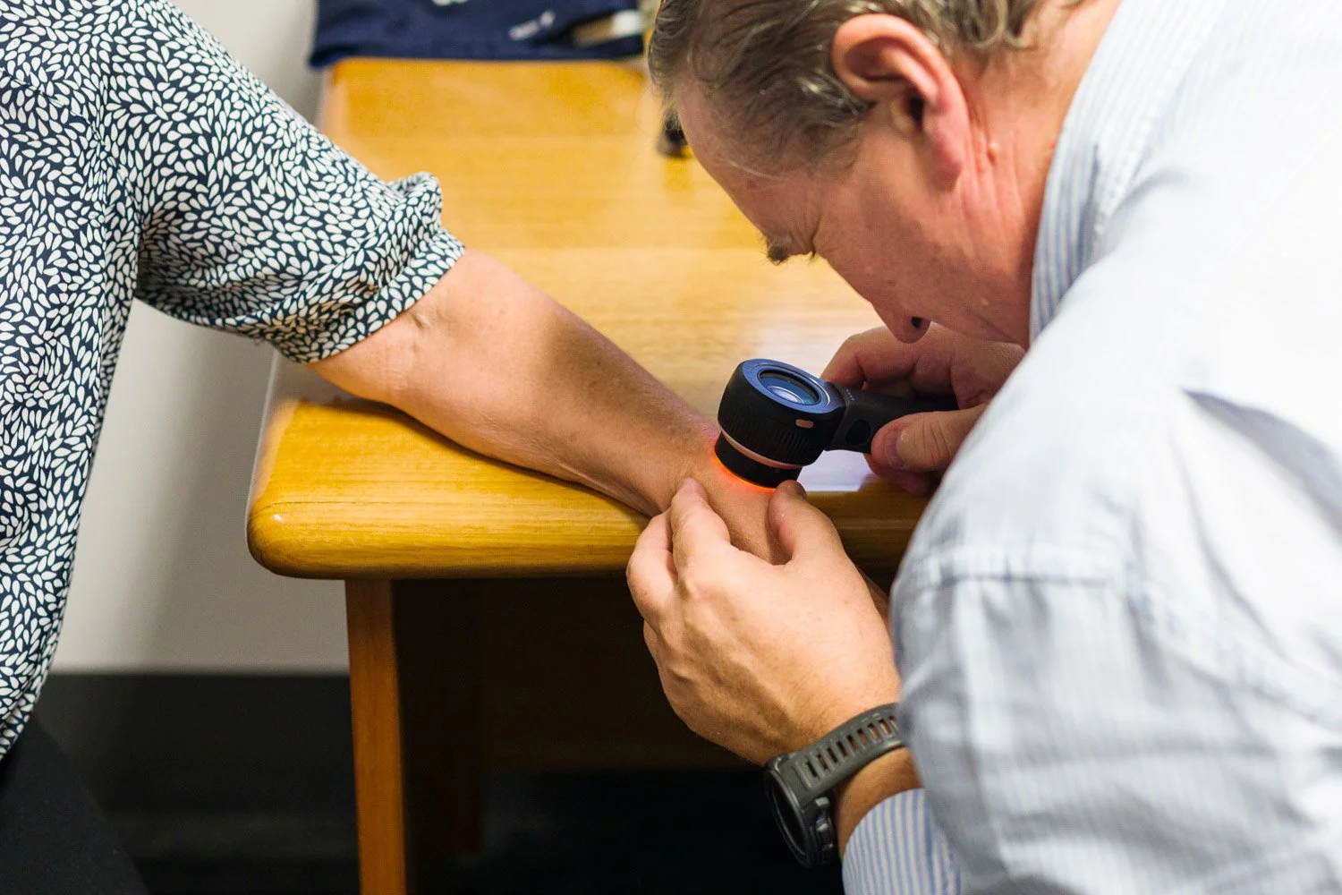 Doctor looking through dermatoscope to check for skin cancer