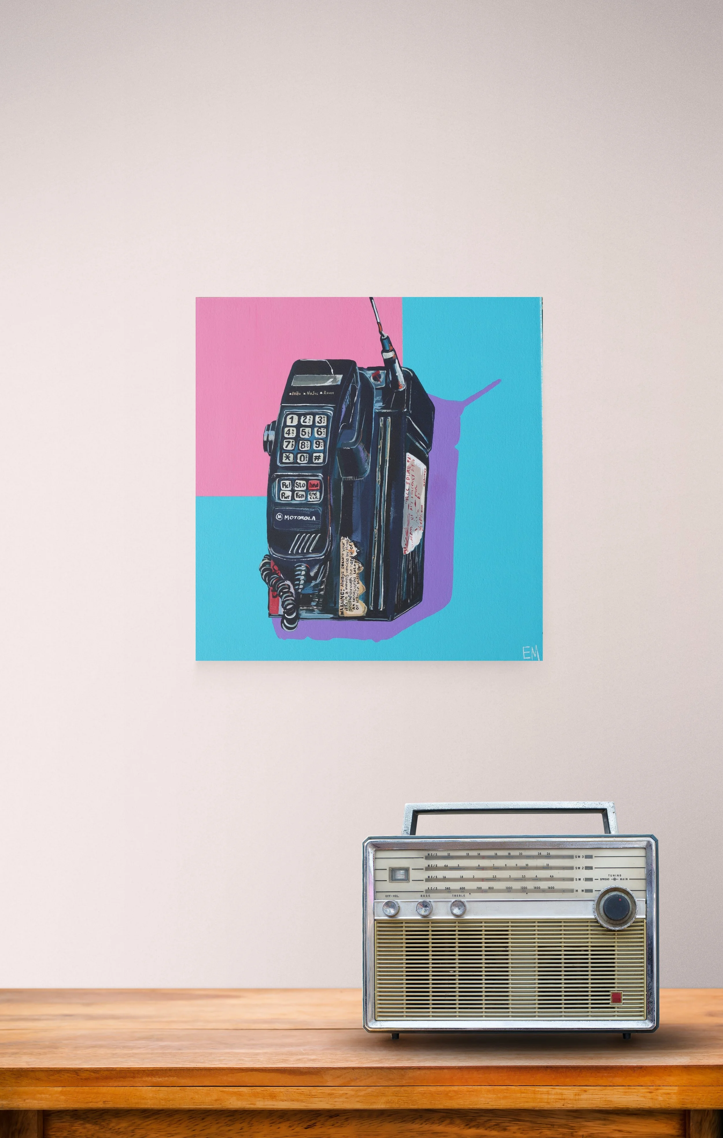 Blue and pink painting with old phone hangs on wall