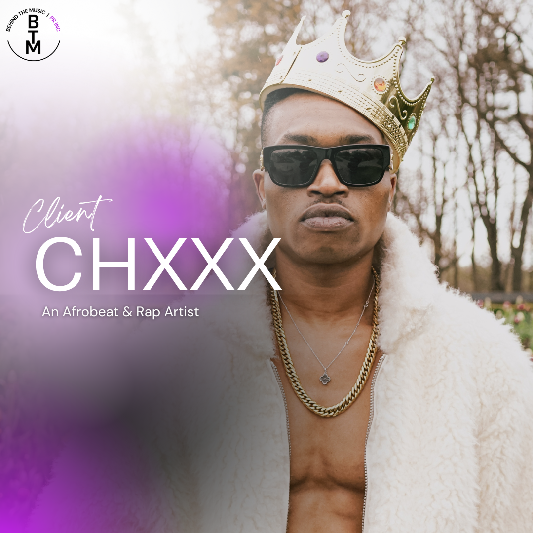 A rapper wearing a gold crown and sunglasses, with a white furry jacket, necklaces, and an open shirt, standing outdoors among trees.