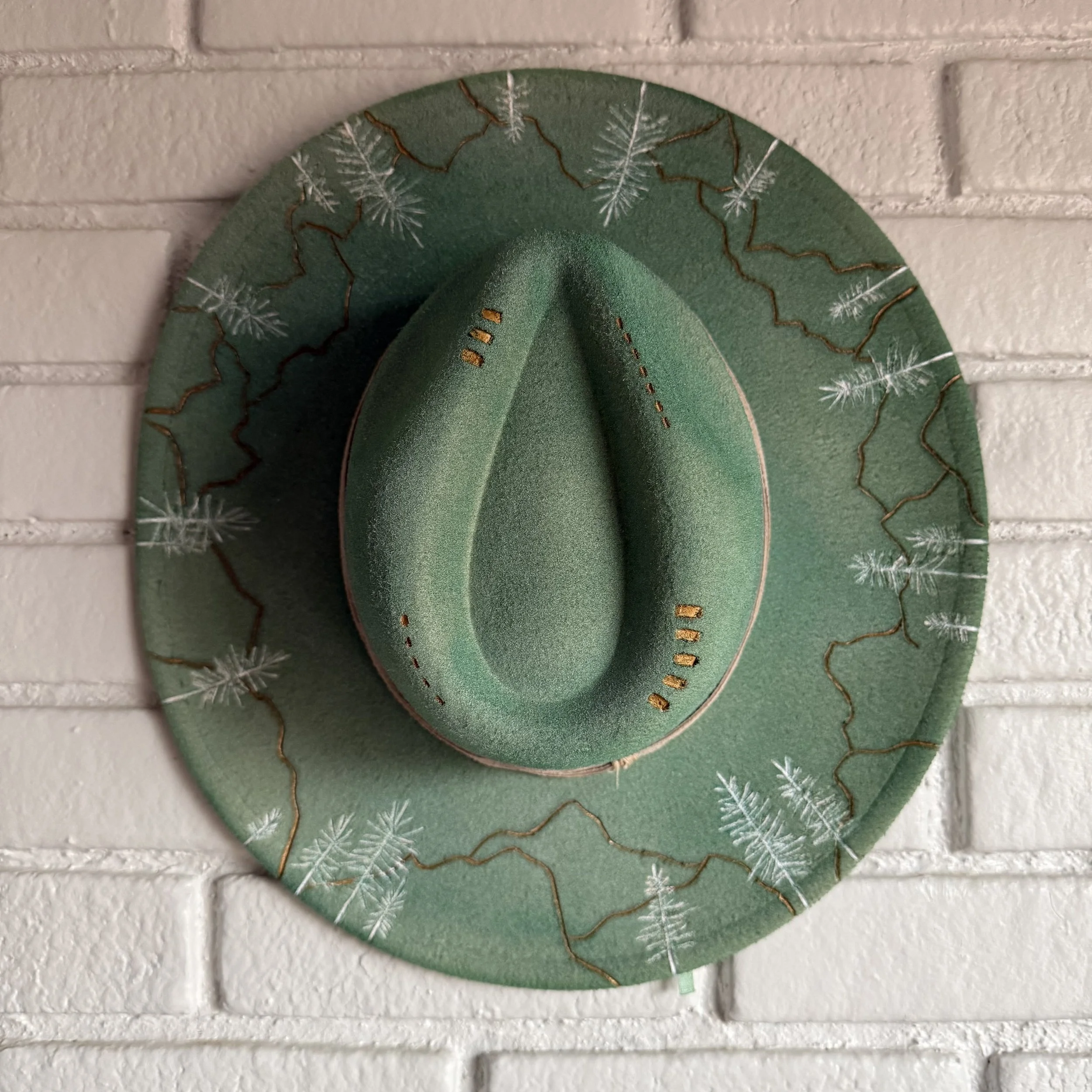 Custom hand-painted western wide-brim hat with sage green felt and gold mountain ridges - Amyzing Art Studios