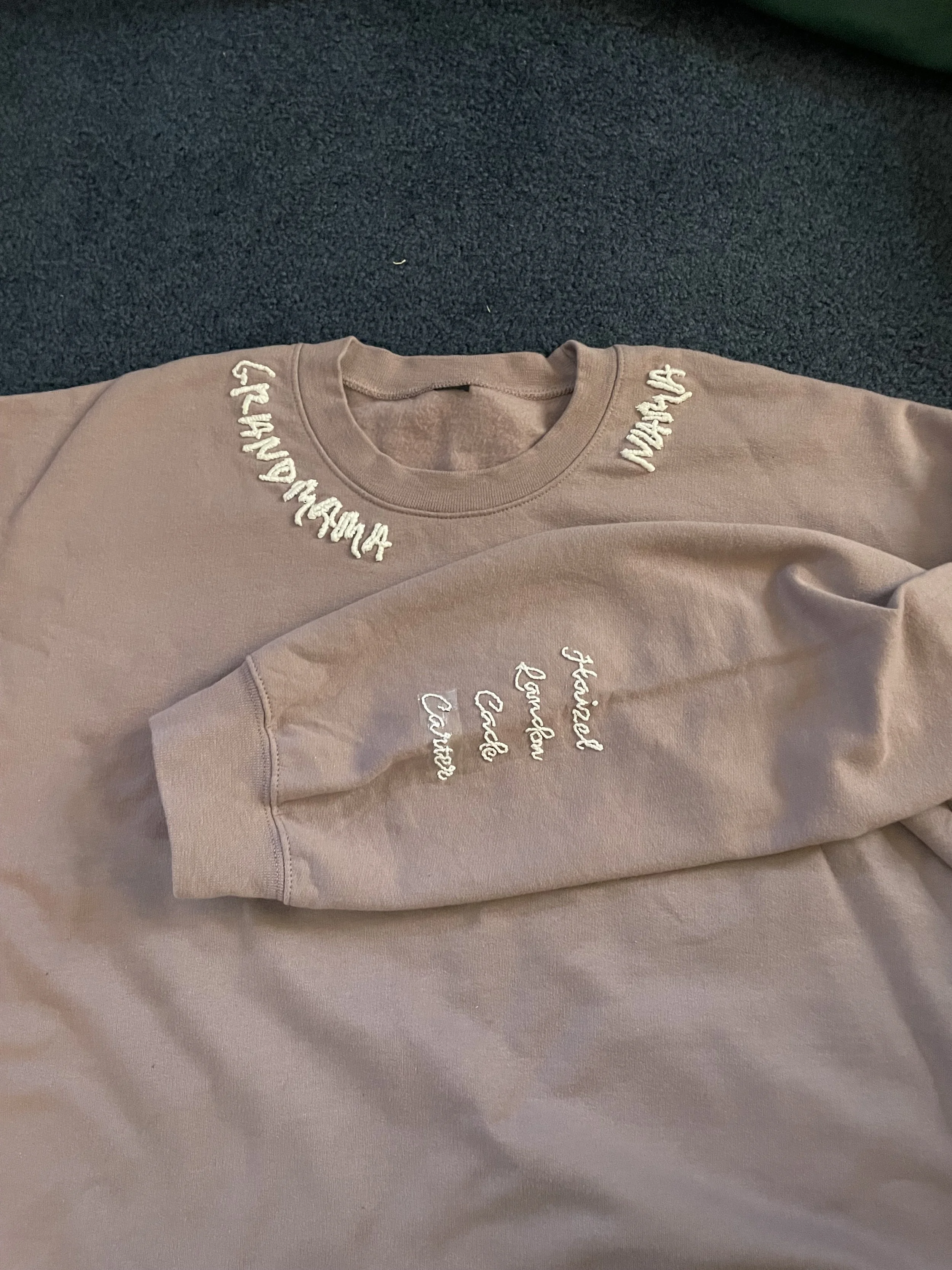 Light purple sweatshirt with embroidered text on the collar and sleeve