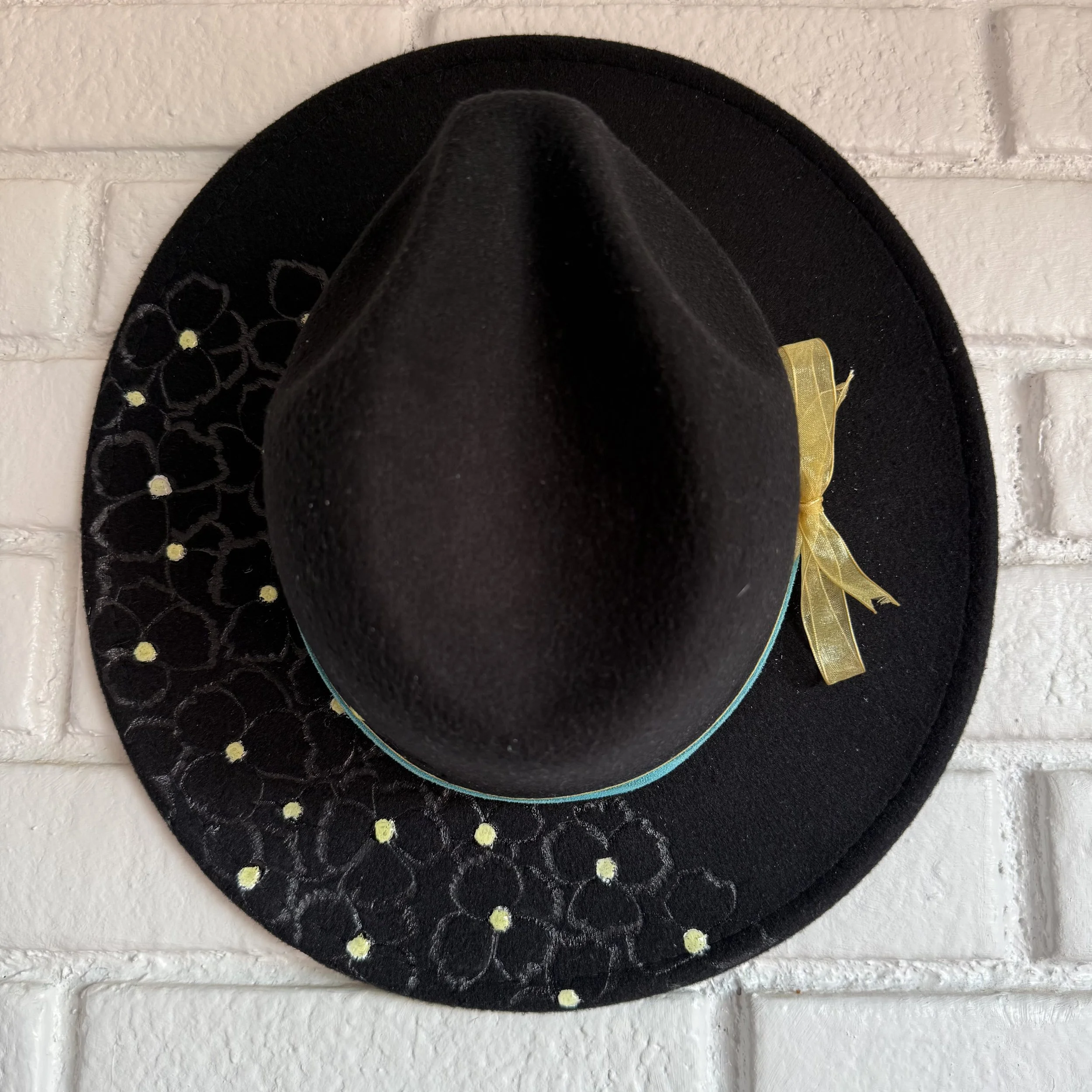 black wide brim hat with Three Brothers Bloom flowers burned into the brim.