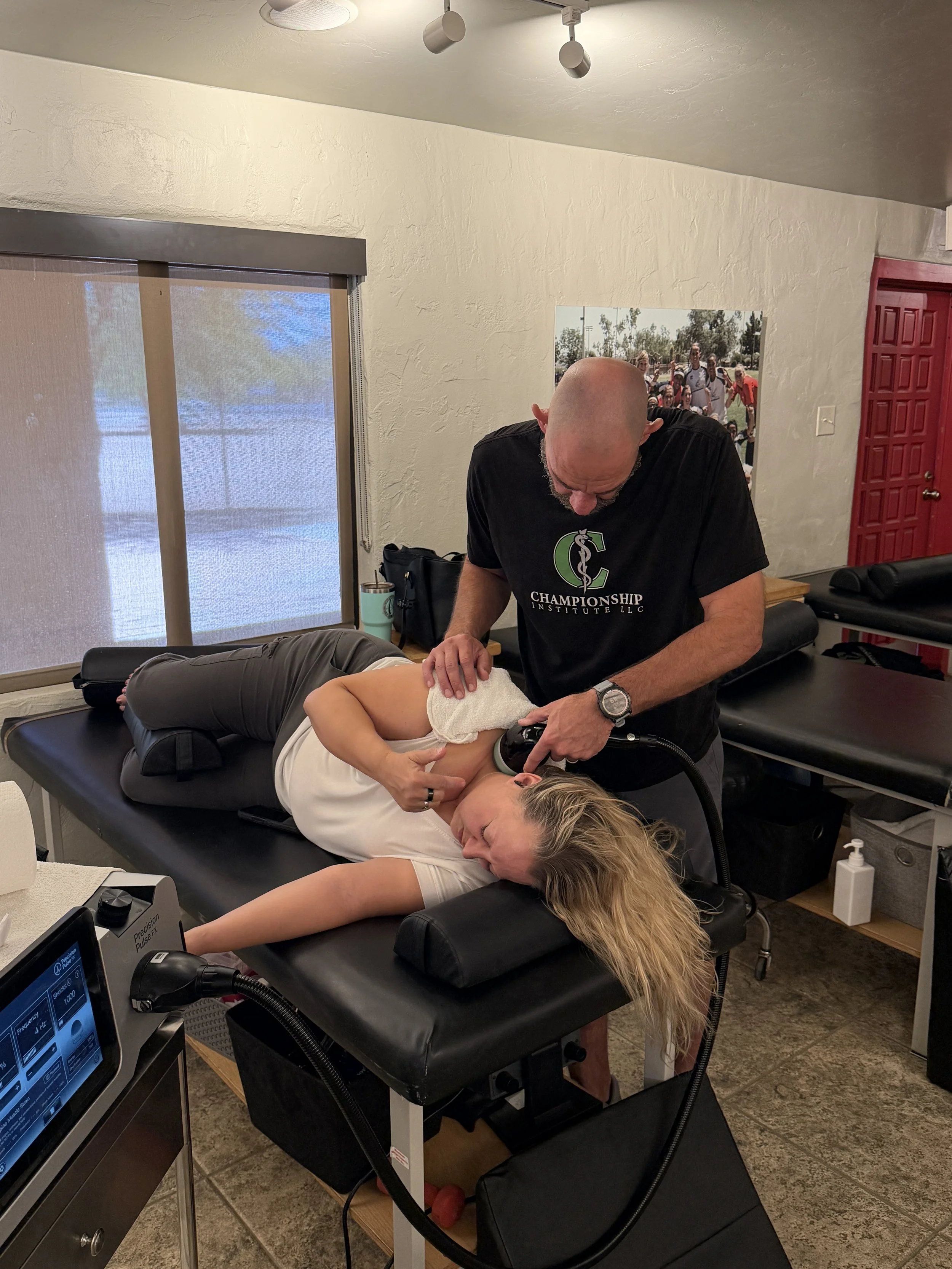Athletic training performing shockwave therapy on a womans neck at Championship Institute in Tucson, Arizona