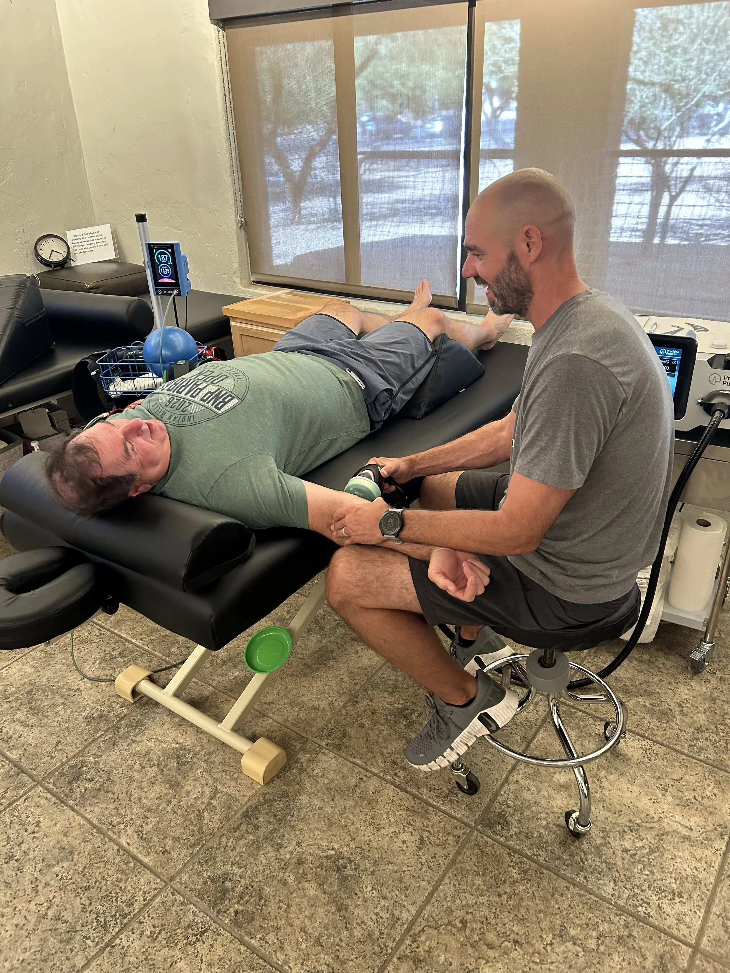 Athletic trainer performing shockwave therapy on an arm injury in Tucson Arizona, Championship Institution