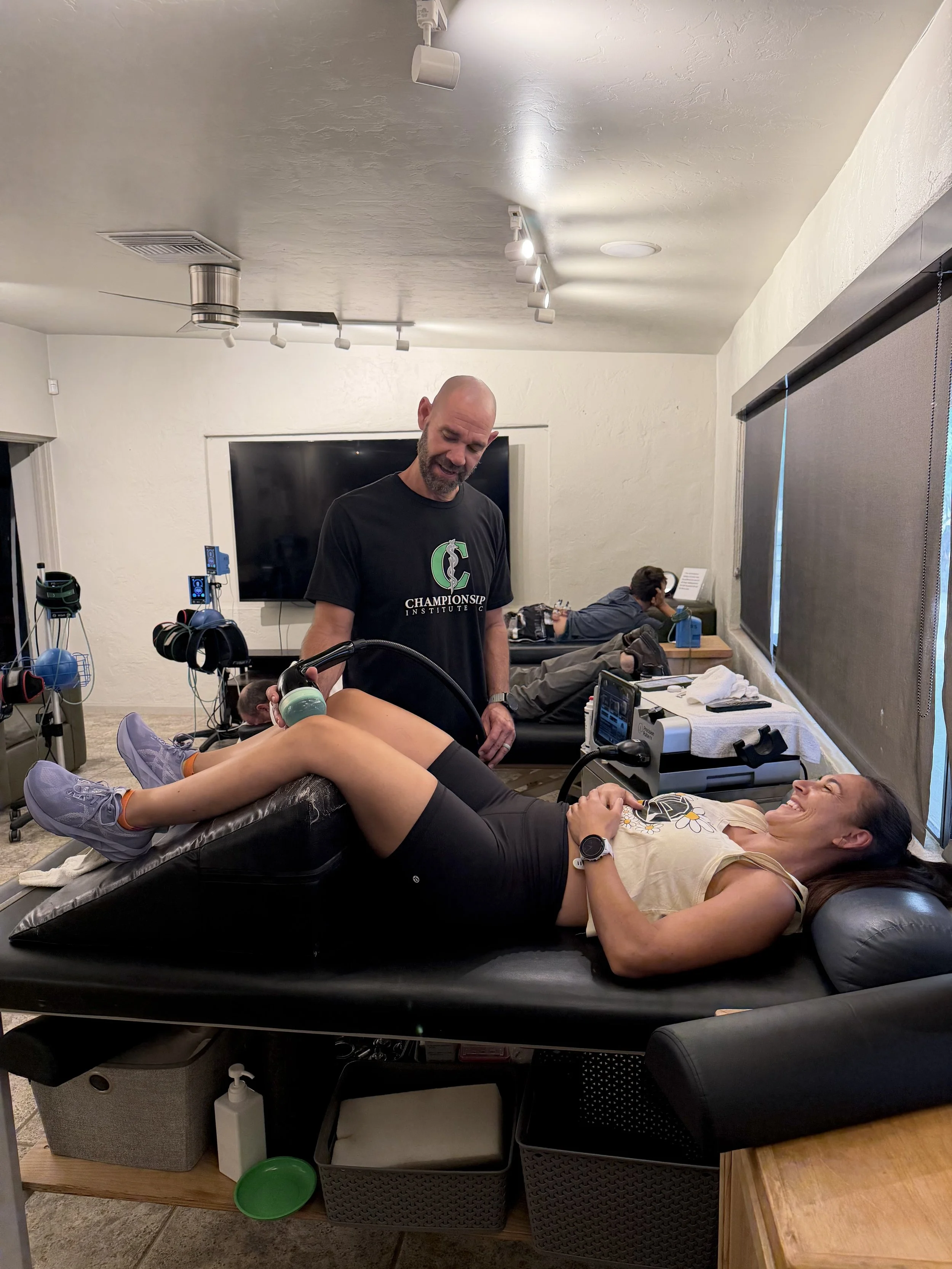 Athletic training performing shockwave therapy on a womans leg at Championship Institute in Tucson, Arizona