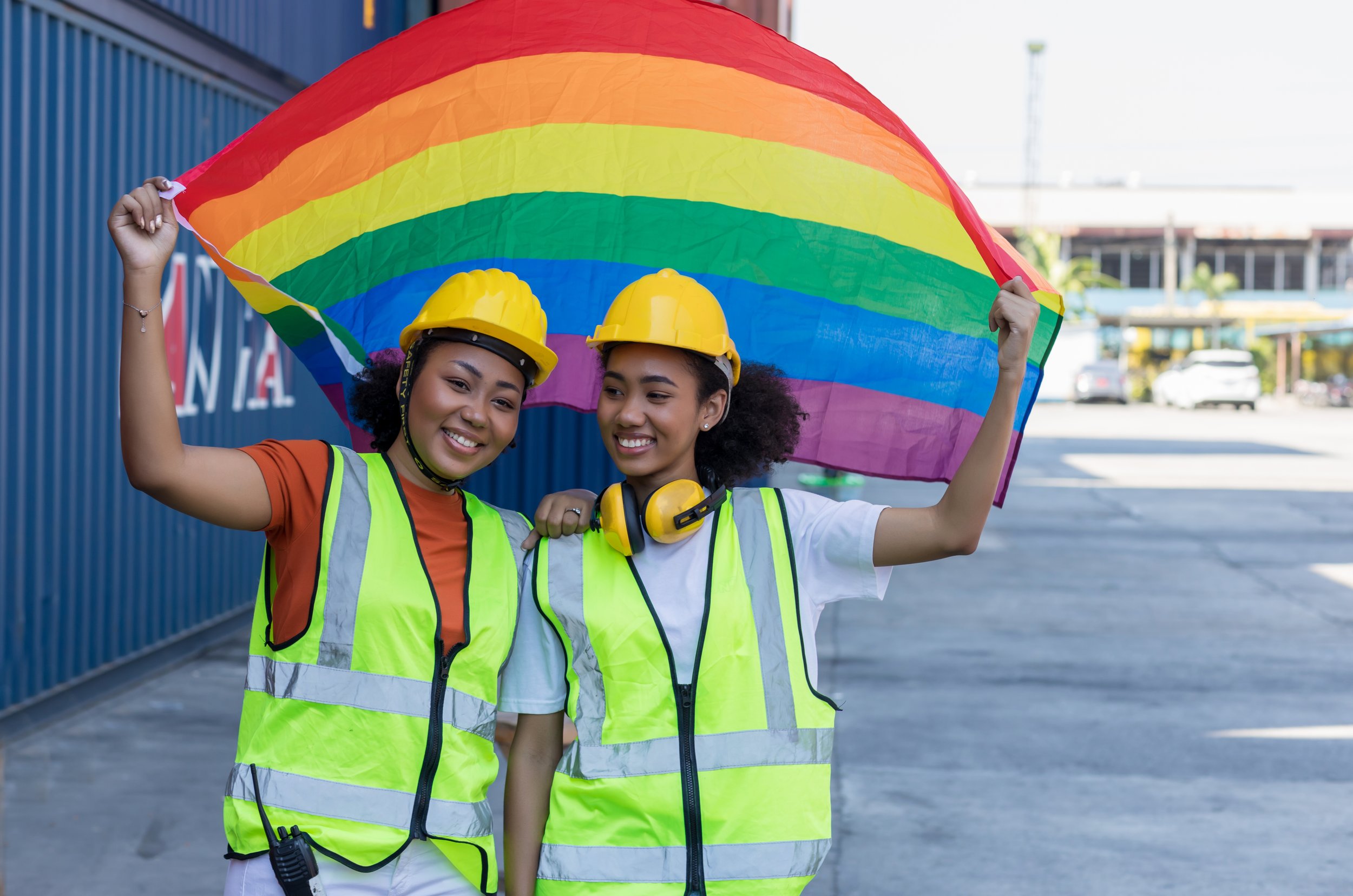 Two people celebrating Pride Month at work representing CultureAlly's Pride Month virtual training for teams - whether remote or in person.