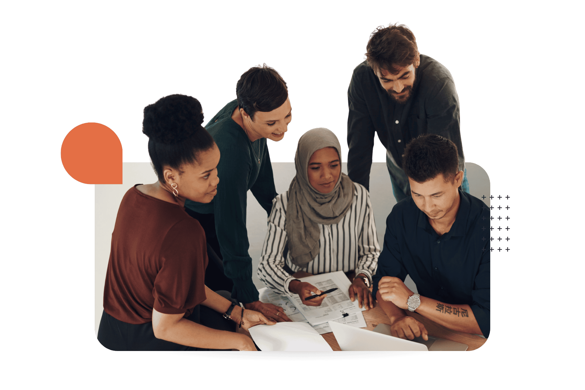 Five diverse colleagues gathered around a table reviewing documents together during a collaborative work session.