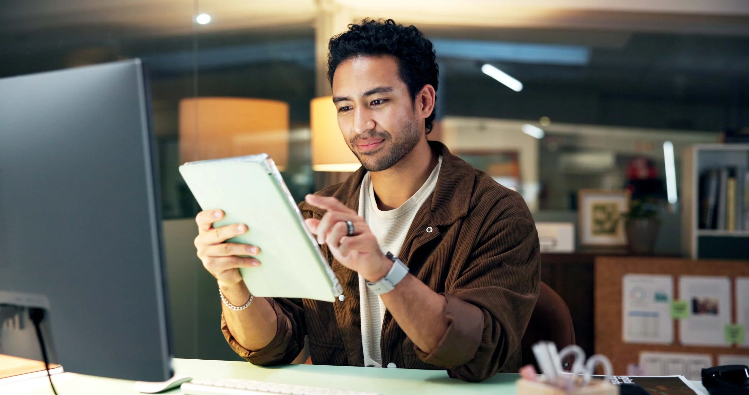 Person at desk looking at their tablet featuring the CultureAlly free resource.